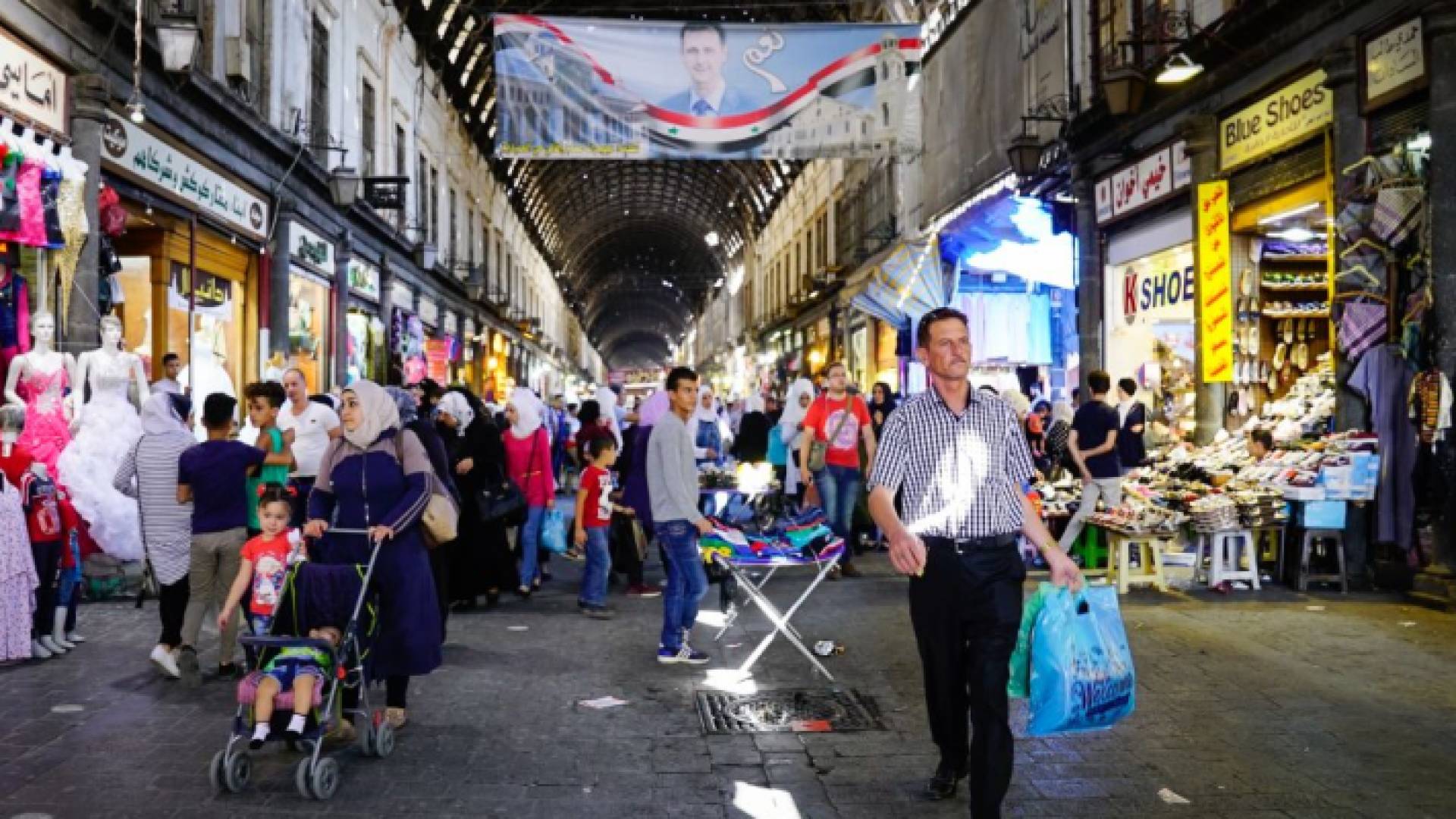 سوريون في أحد الأسواق - أرشيفية