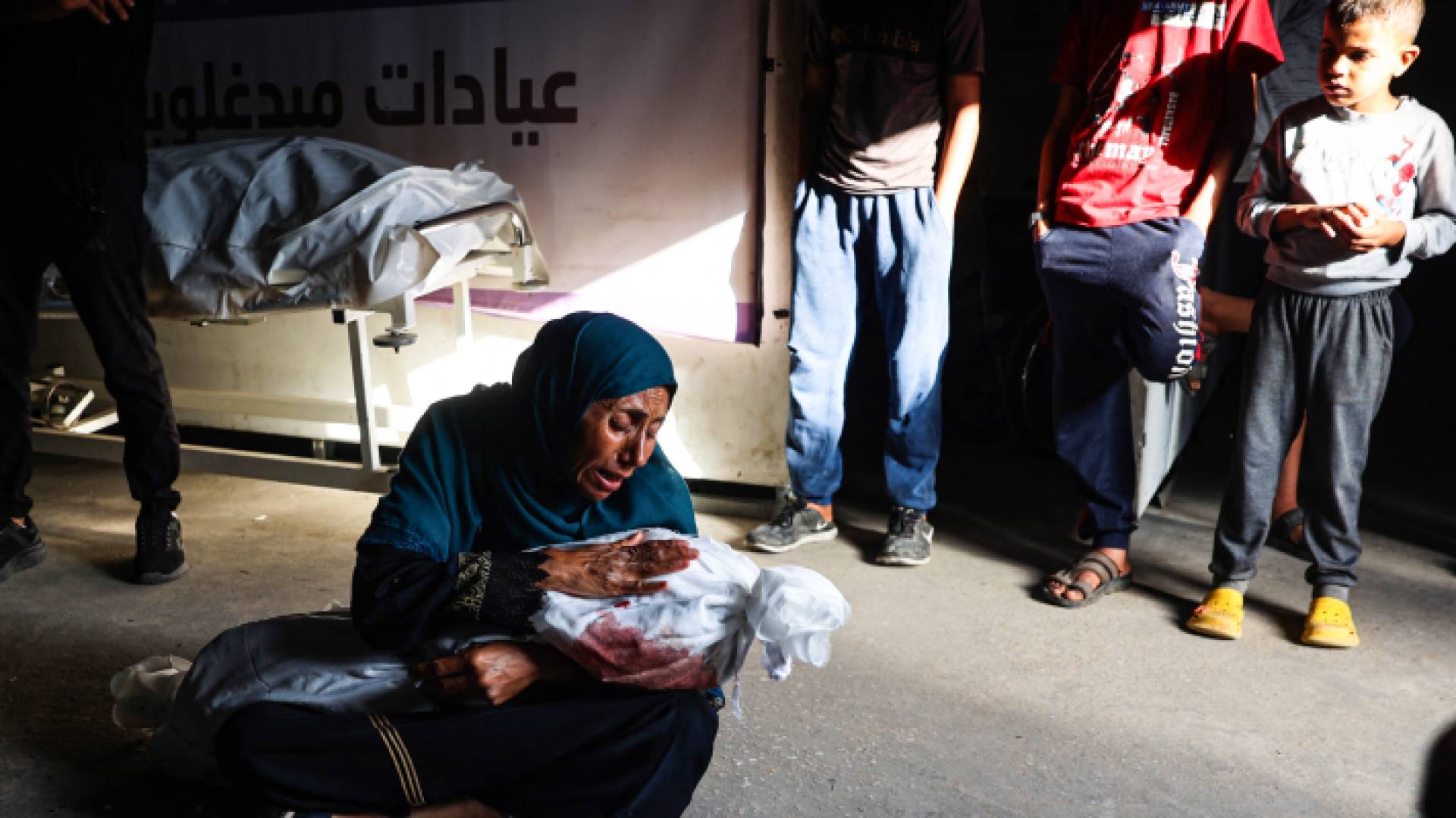 سيدة فلسطينية تحمل طفل استشهد في رفح