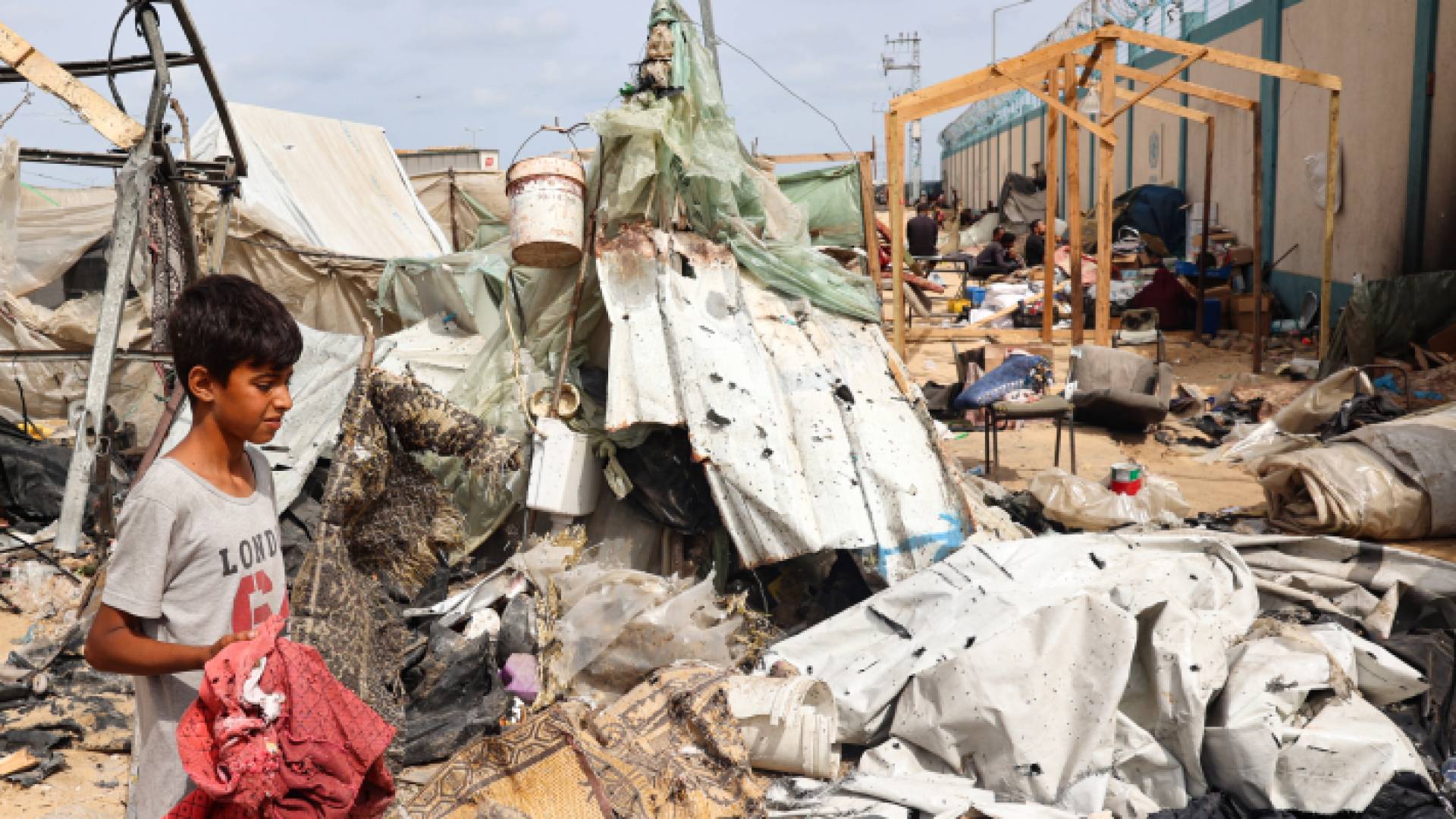فتى فلسطيني يبحث في الأنقاض في موقع تعرض لقصف الاحتلال في مخيم للنازحين برفح