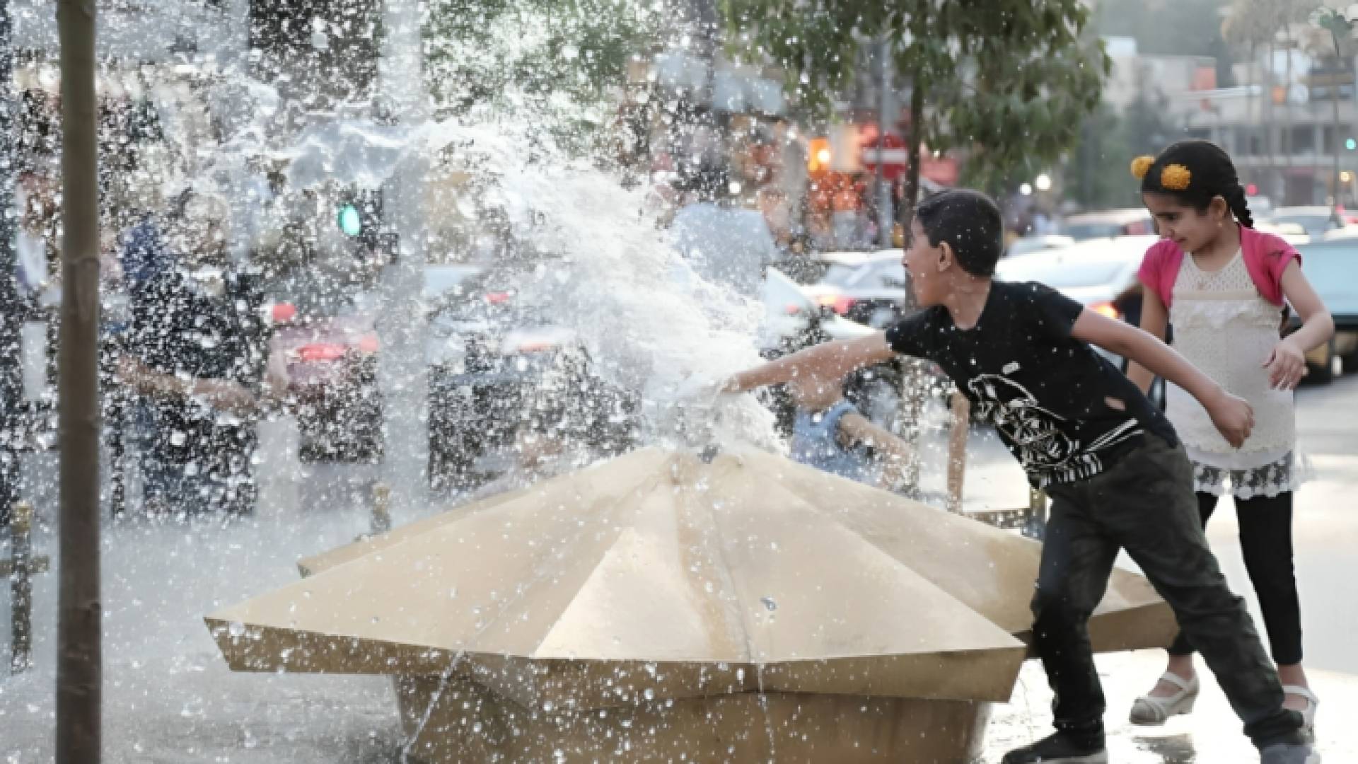 أطفال يلعبون بالمياه في منطقة وسط البلد