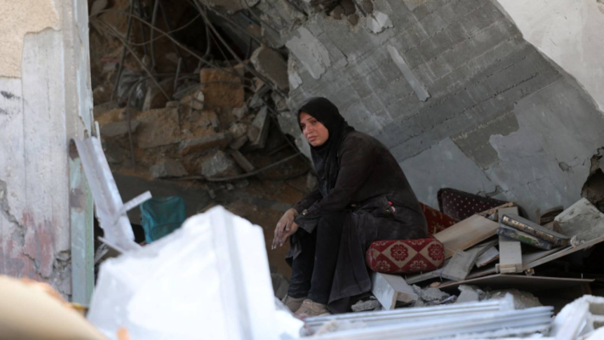فلسطينية تجلس بين ركام منزلها في غزة