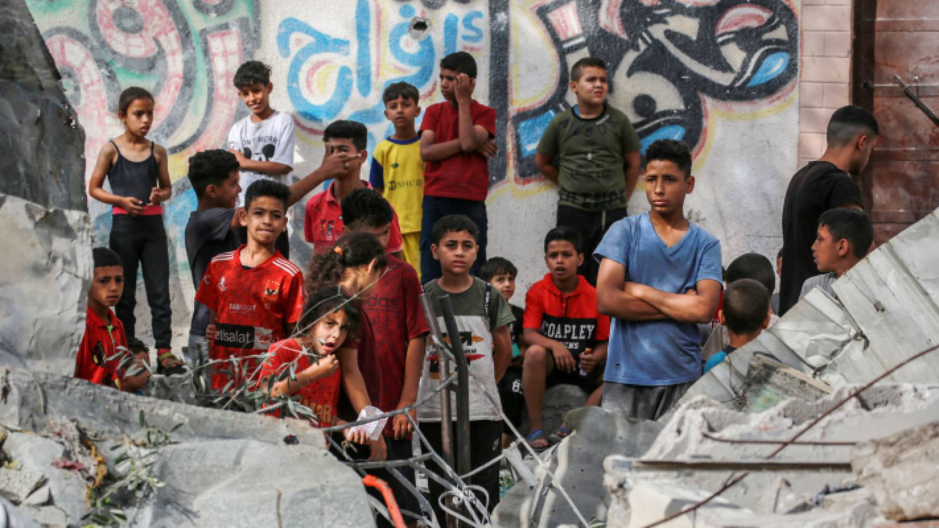 أطفال فلسطينيون يقفون بجوار أنقاض منزل دمر خلال قصف للاحتلال في النصيرات وسط قطاع غزة