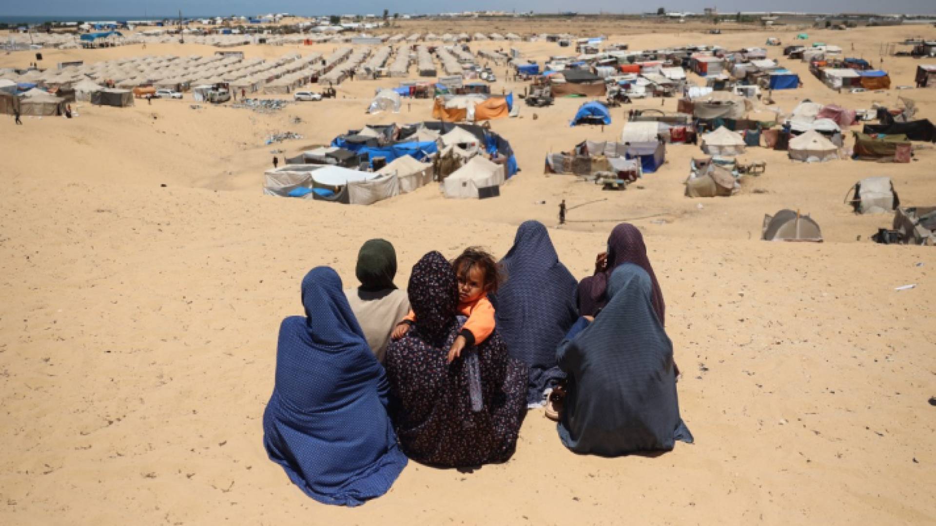 فلسطينيات أمام خيام النزوح في رفح جنوبي قطاع غزة