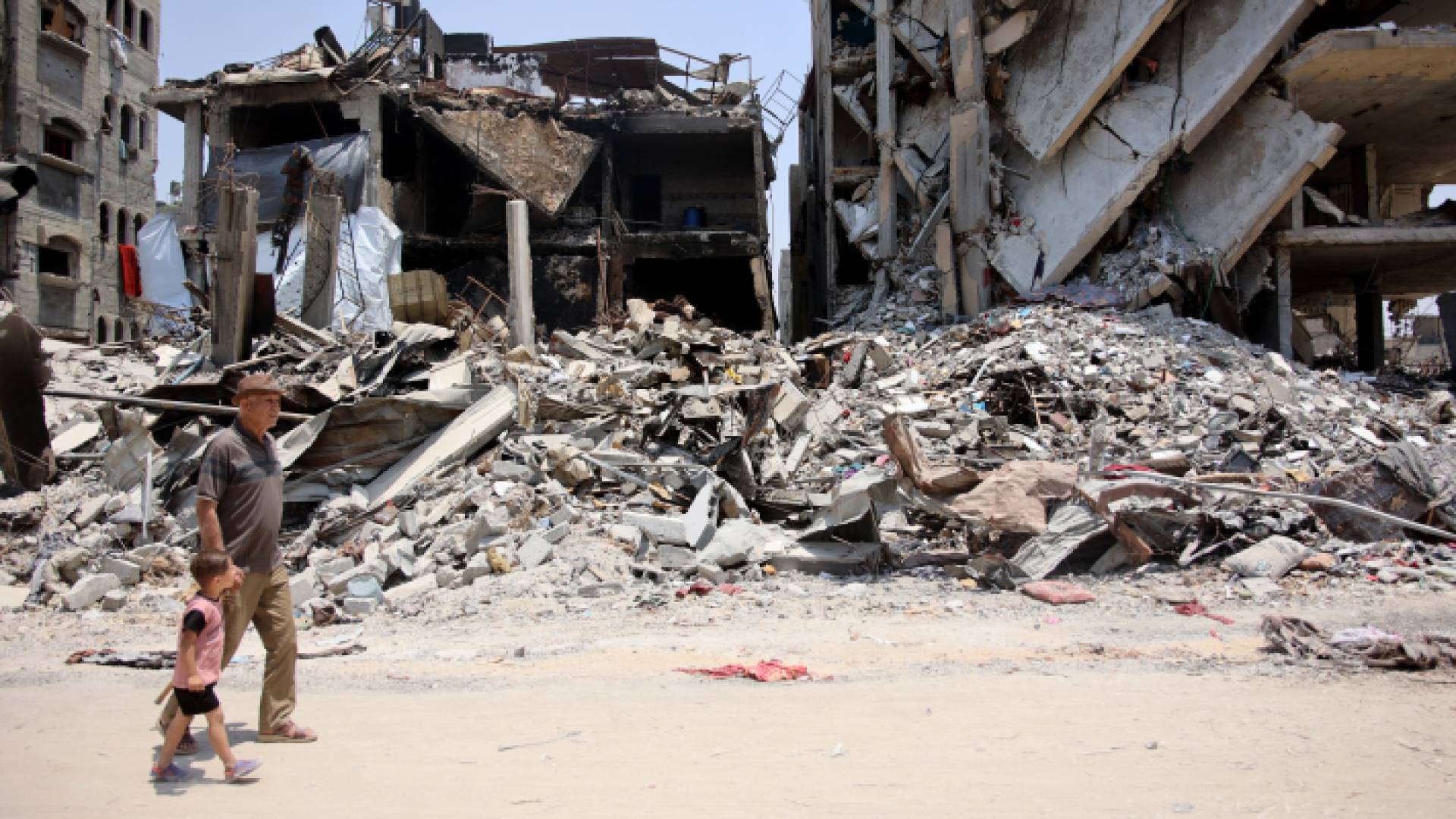 فلسطينيون وسط الدمار في مخيم جباليا بغزة