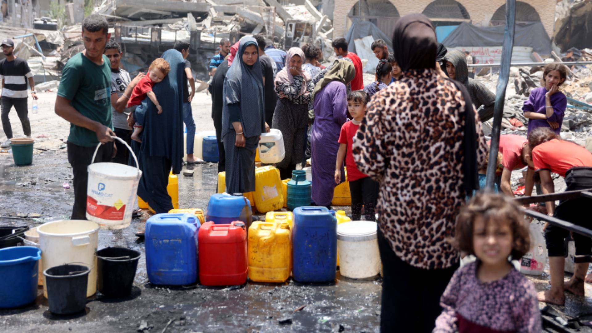 فلسطينيون ينتظرون عبوات مياه في مخيم جباليا