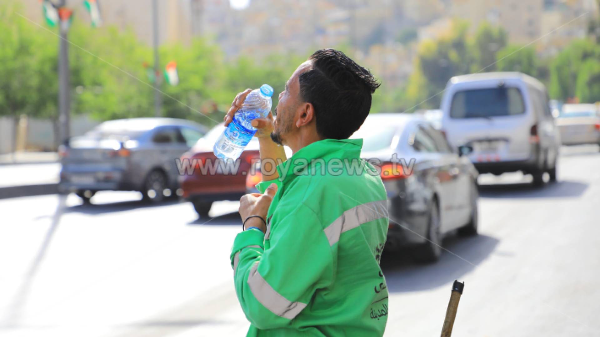 عامل وطن يشرب الماء وسط الأجواء الحارة في العاصمة عمان
