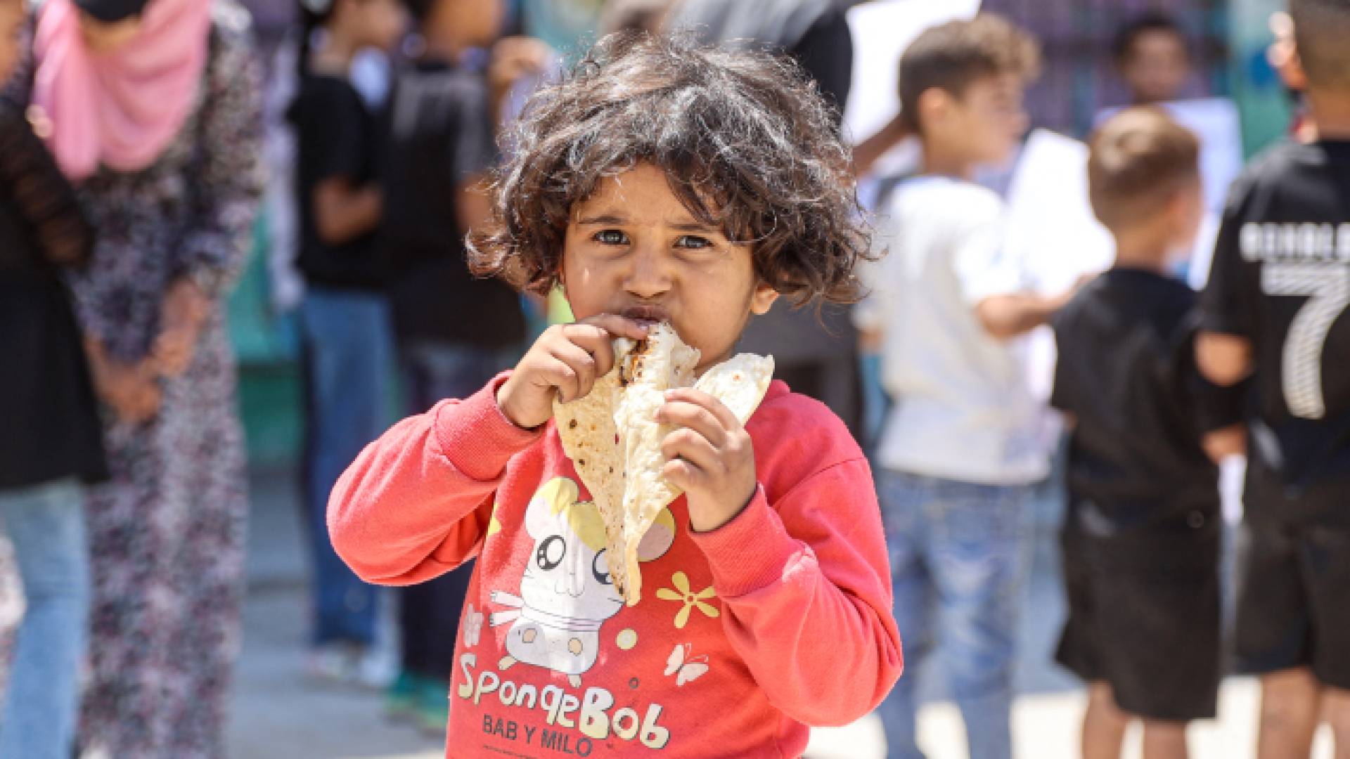 طفلة فلسطينية تأكل الخبز في مدينة غزة