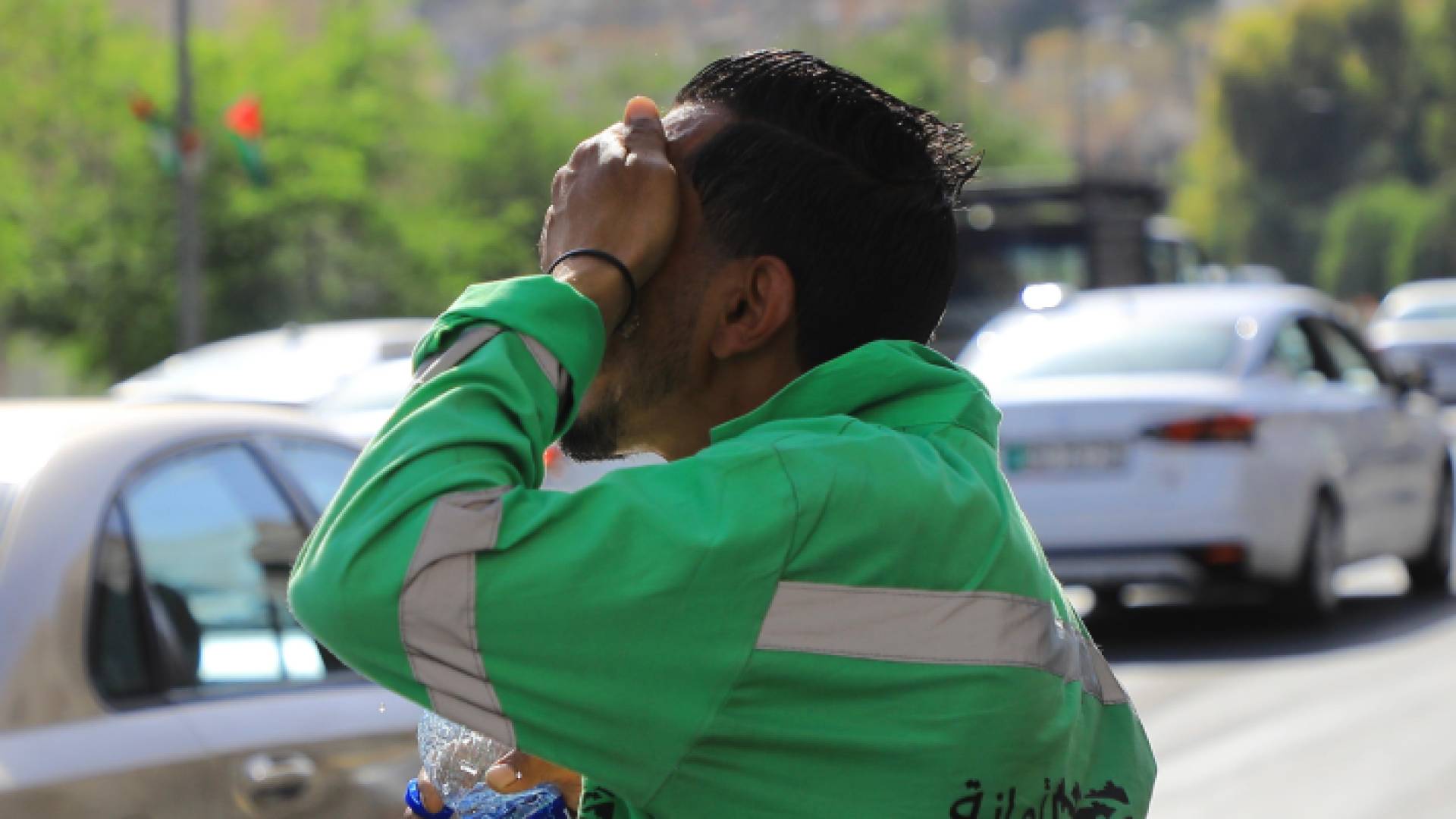 عامل وطن في العاصمة عمان يعمل تحت أشعة الشمس