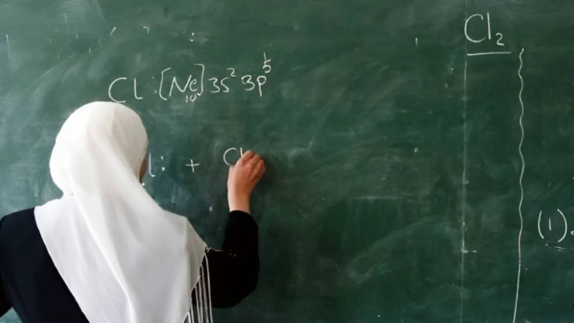 معلمة تكتب على السبورة