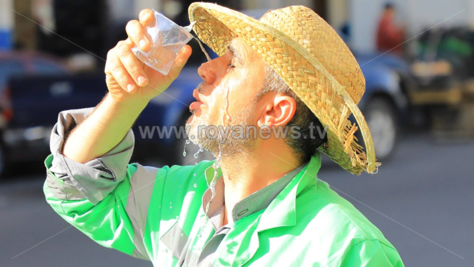 عامل وطن يسكب المياه على وجهه بسبب ارتفاع درجات الحرارة في عمان