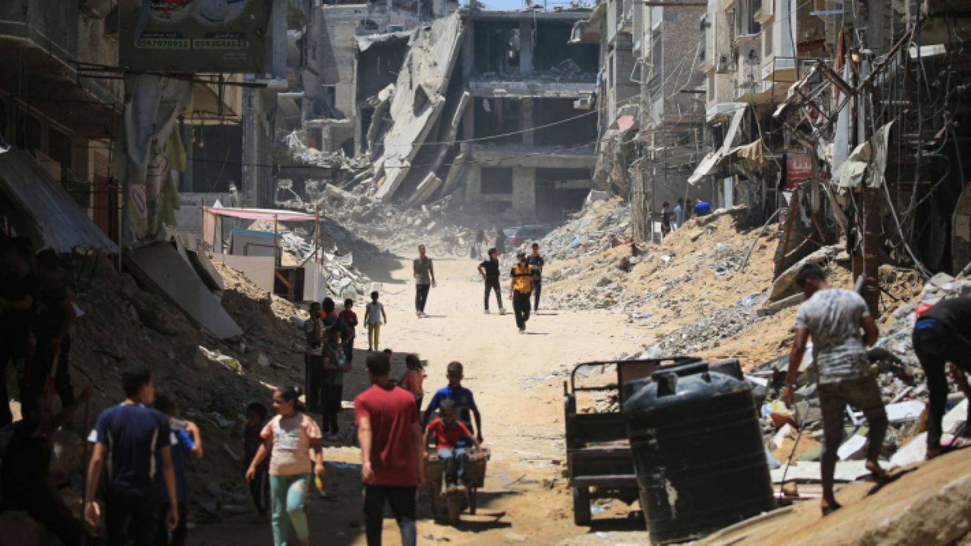 فلسطينيون بجوار المباني المدمرة جراء عدوان الاحتلال على غزة