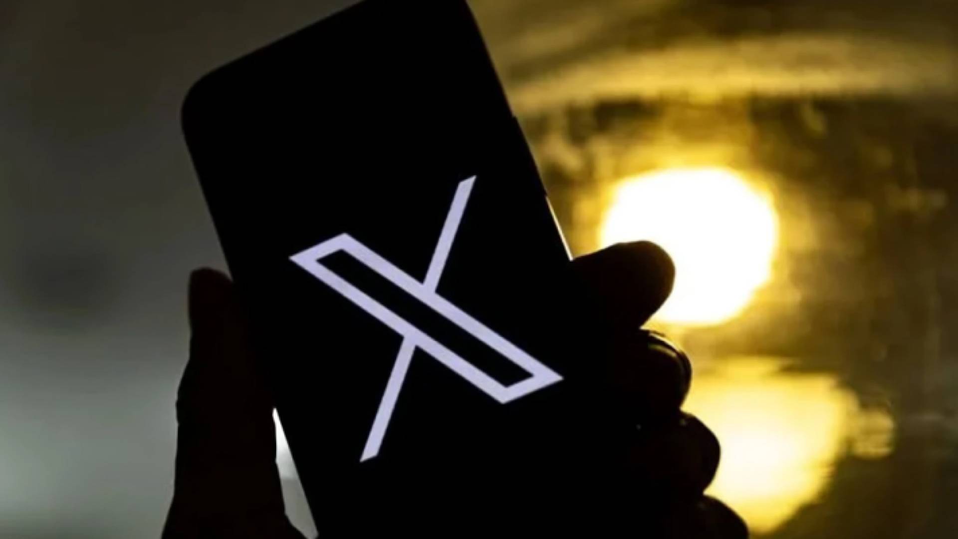 شخص يحمل هاتفا محمولا ويتصفح منصة إكس