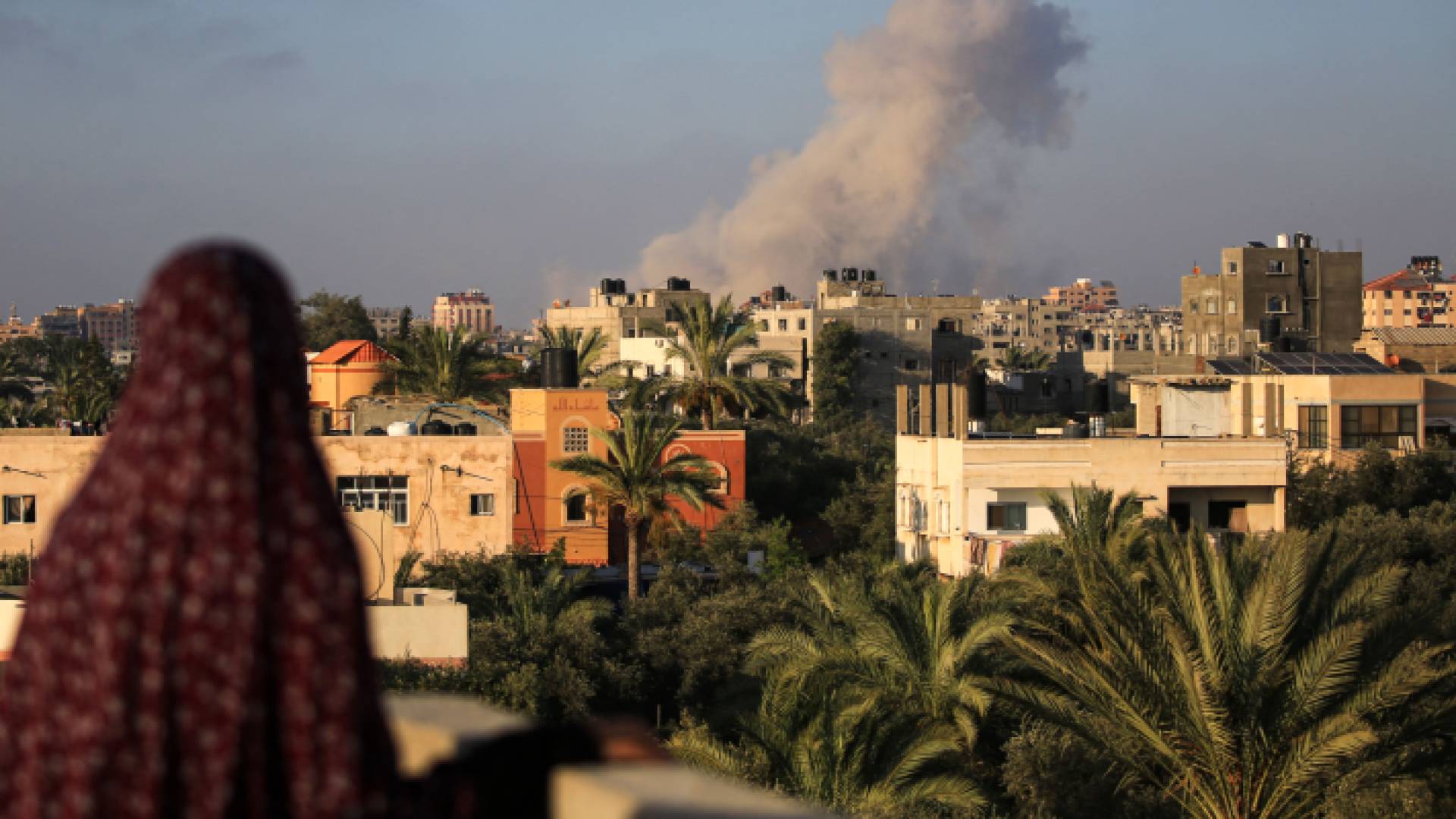 امرأة فلسطينية تراقب تصاعد الدخان في أعقاب غارة للاحتلال في بلدة الزوايدة بوسط قطاع غزة