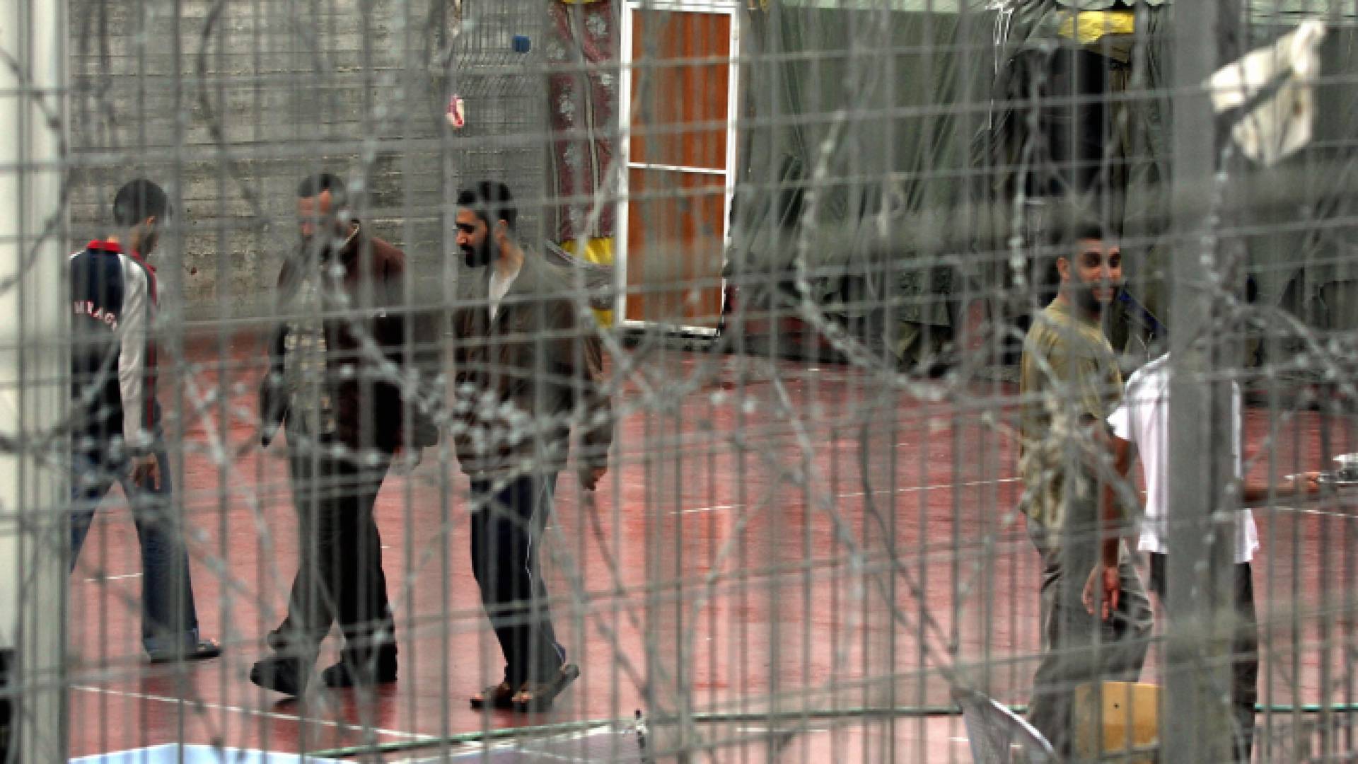 أسرى فلسطينيون يسيرون في ساحة سجن مجدو حيث يُحتجز المعتقلون الإداريون