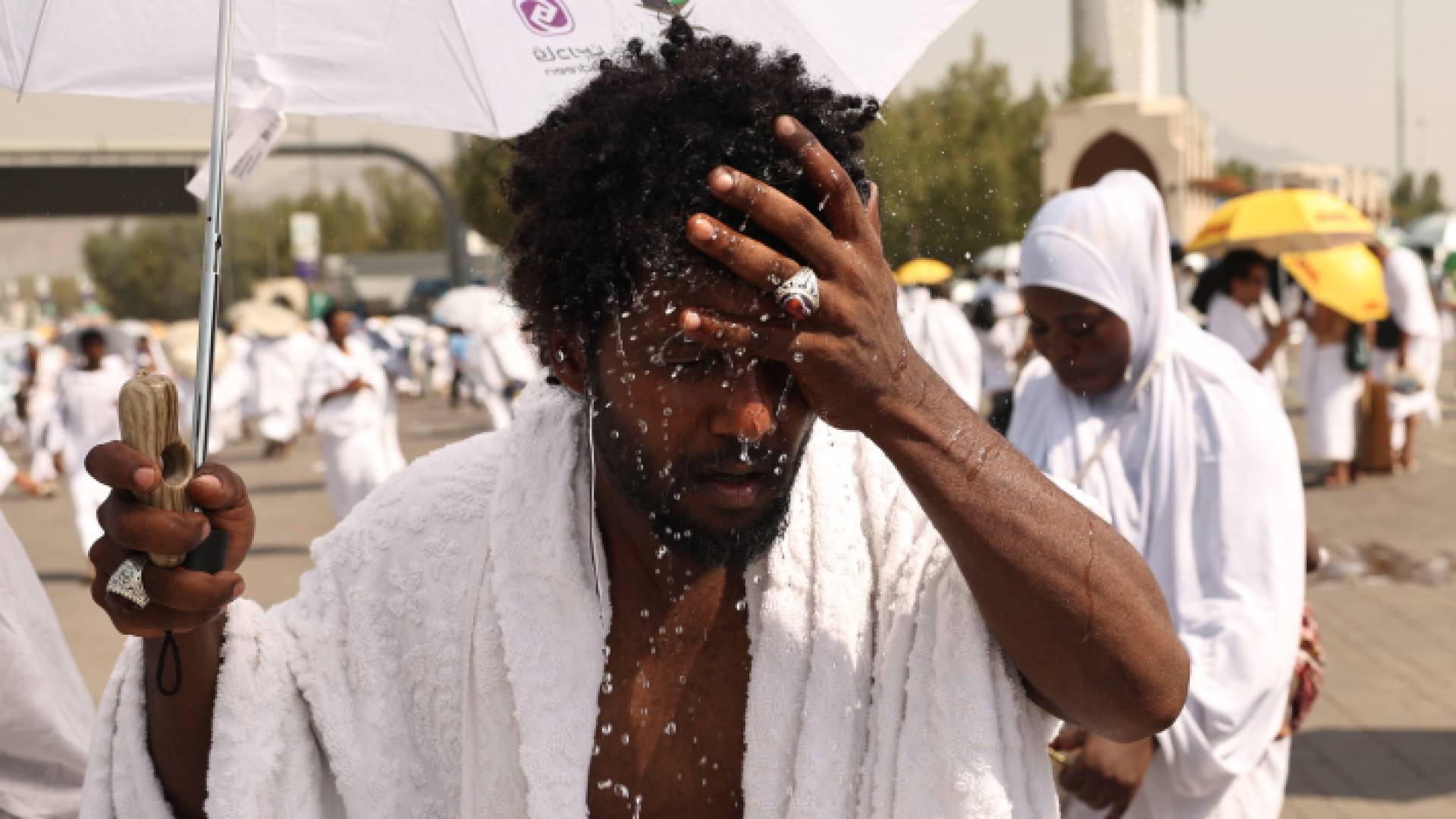 حاج يرش الماء على رأسه