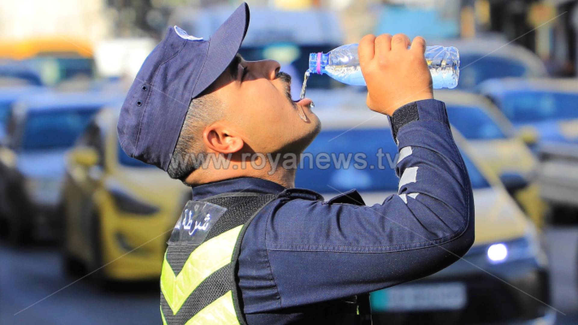 رجل أمن يشرب المياه في ظل ارتفاع درجات الحرارة