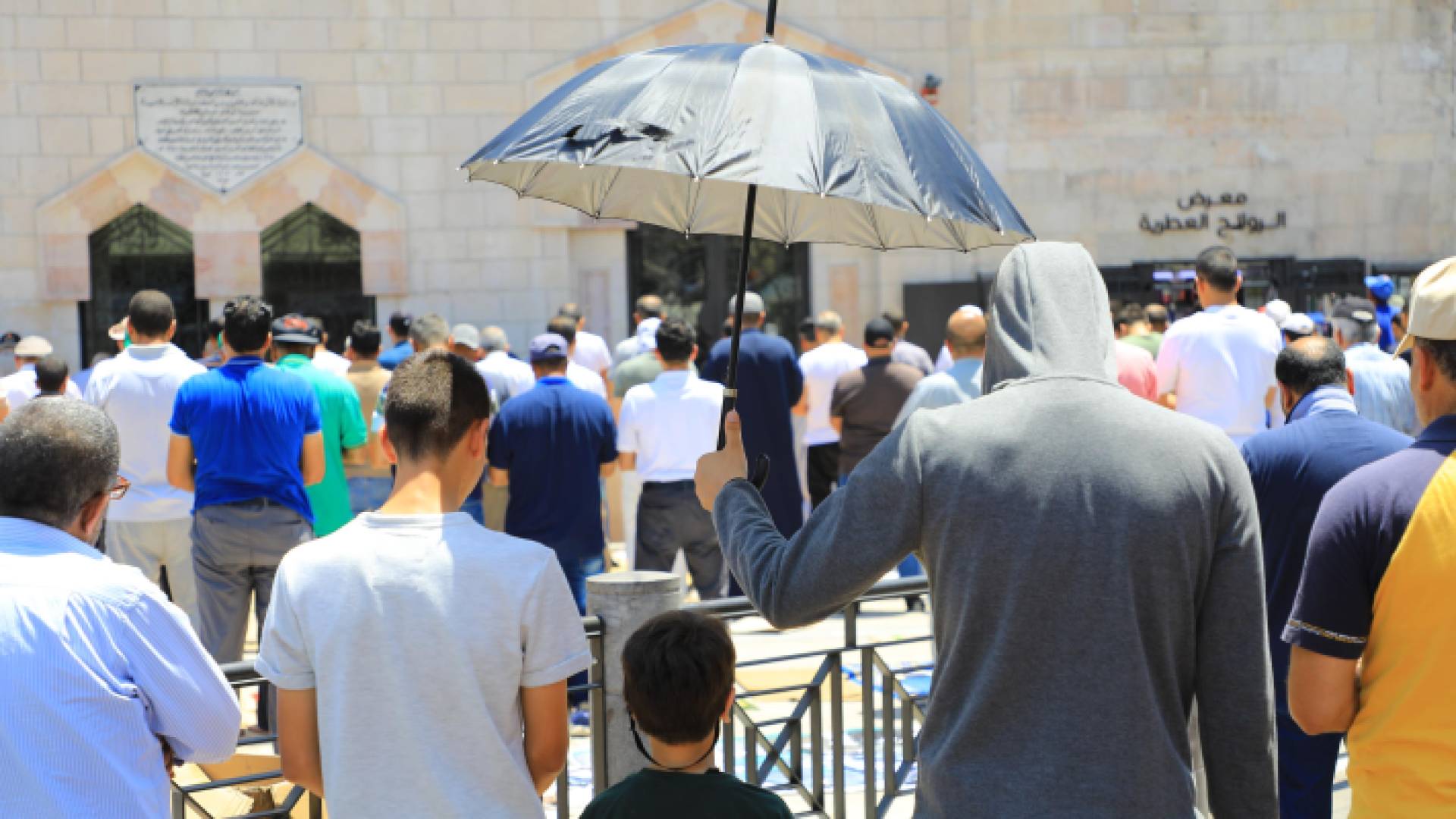 مواطن يحمل شمسية وسط الأجواء الحارة بالعاصمة عمان