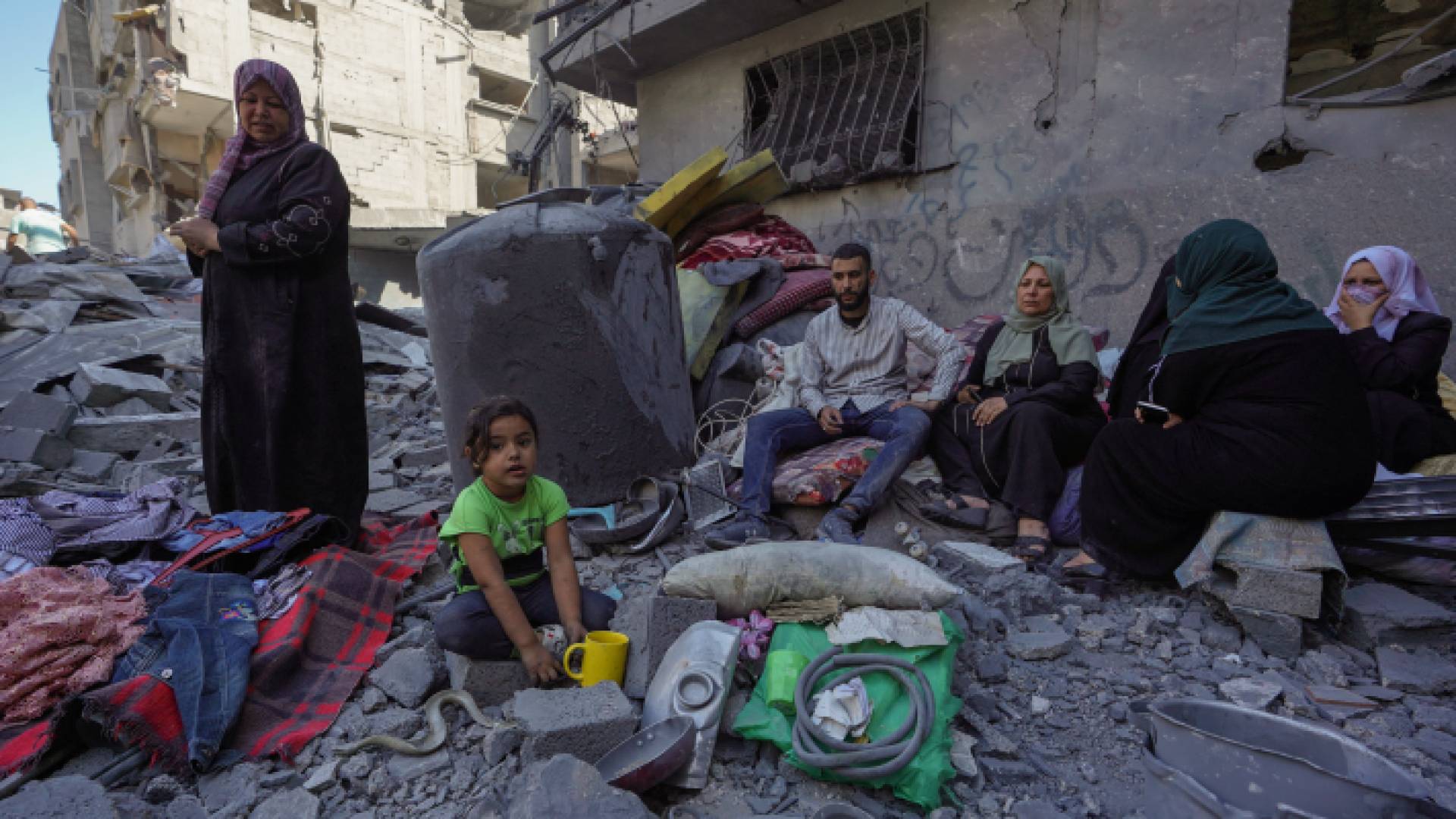 فلسطينيون يجلسون على أنقاض منزل دمره الاحتلال في مخيم البريج للاجئين في وسط قطاع غزة