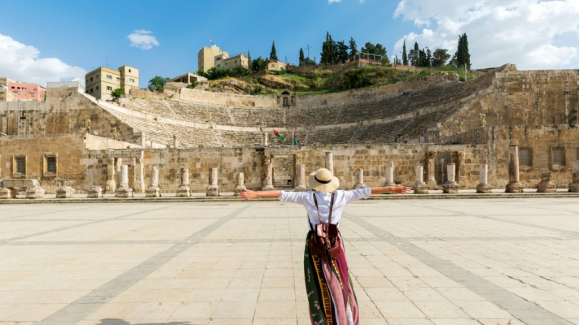 فتاة تقف في المدرج الروماني وسط العاصمة عمان