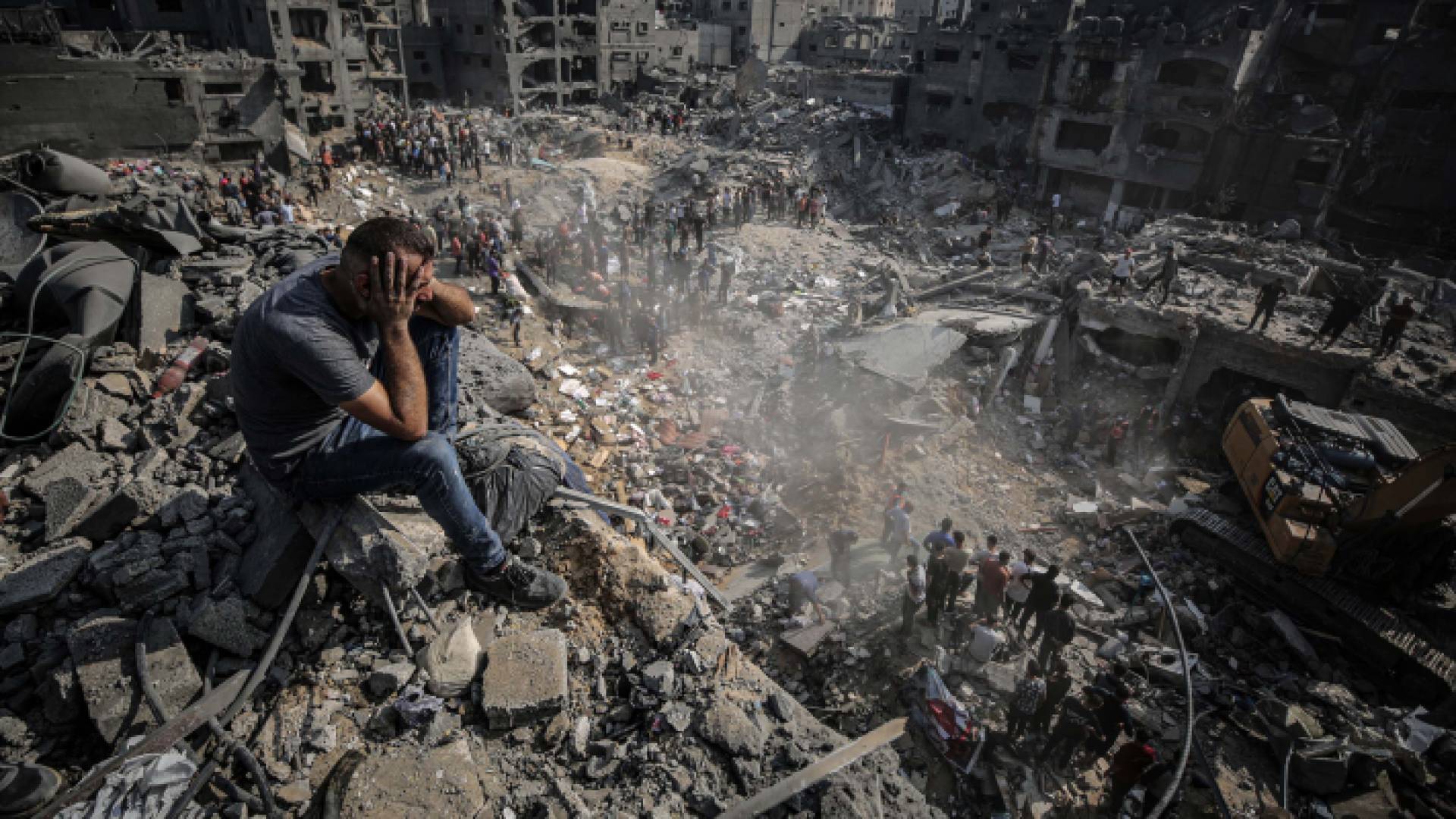 فلسطيني يجلس فوق أنقاض البيوت المدمرة في قطاع غزة