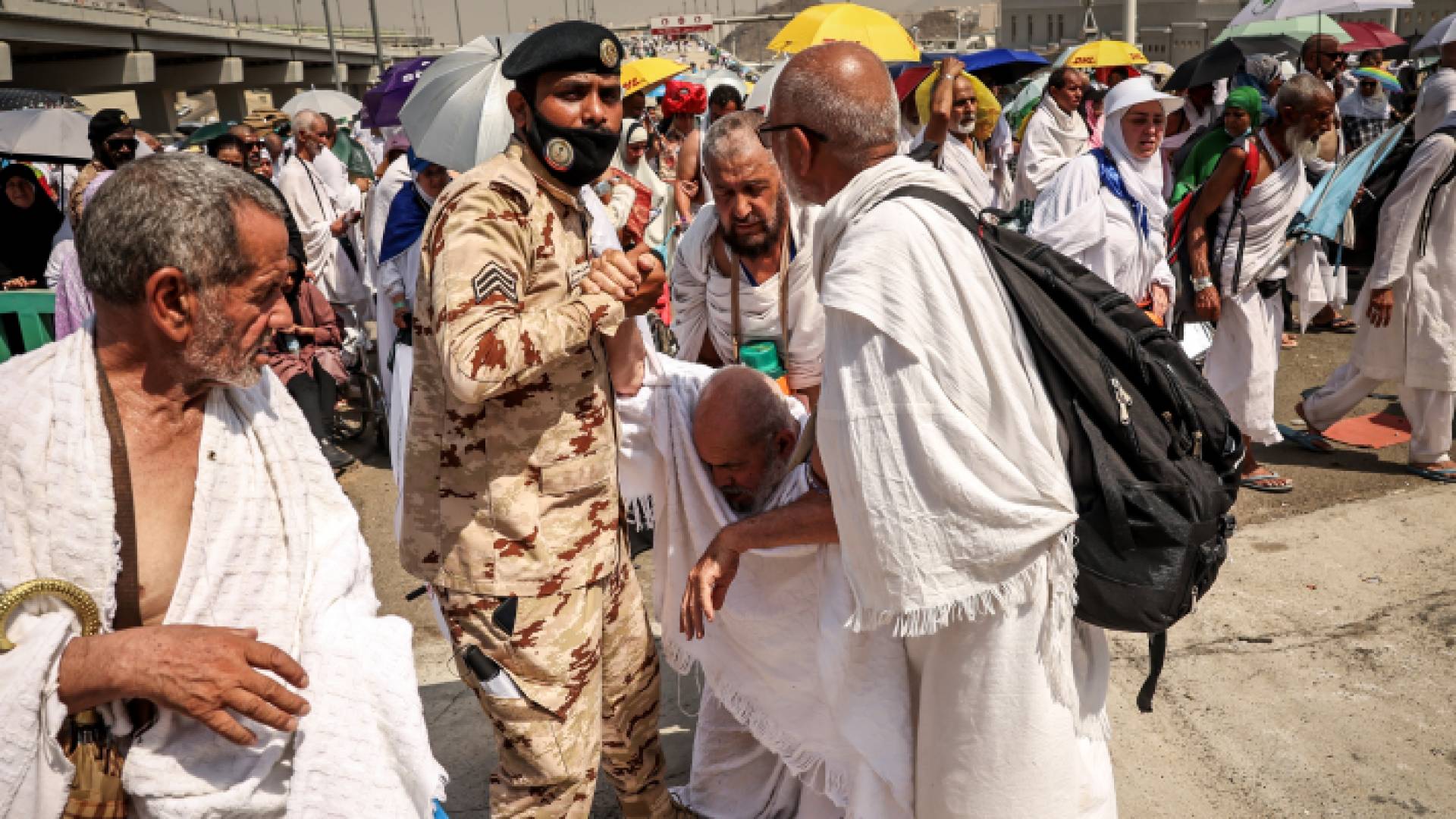رجل أمن سعودي يساعد حاج في منى