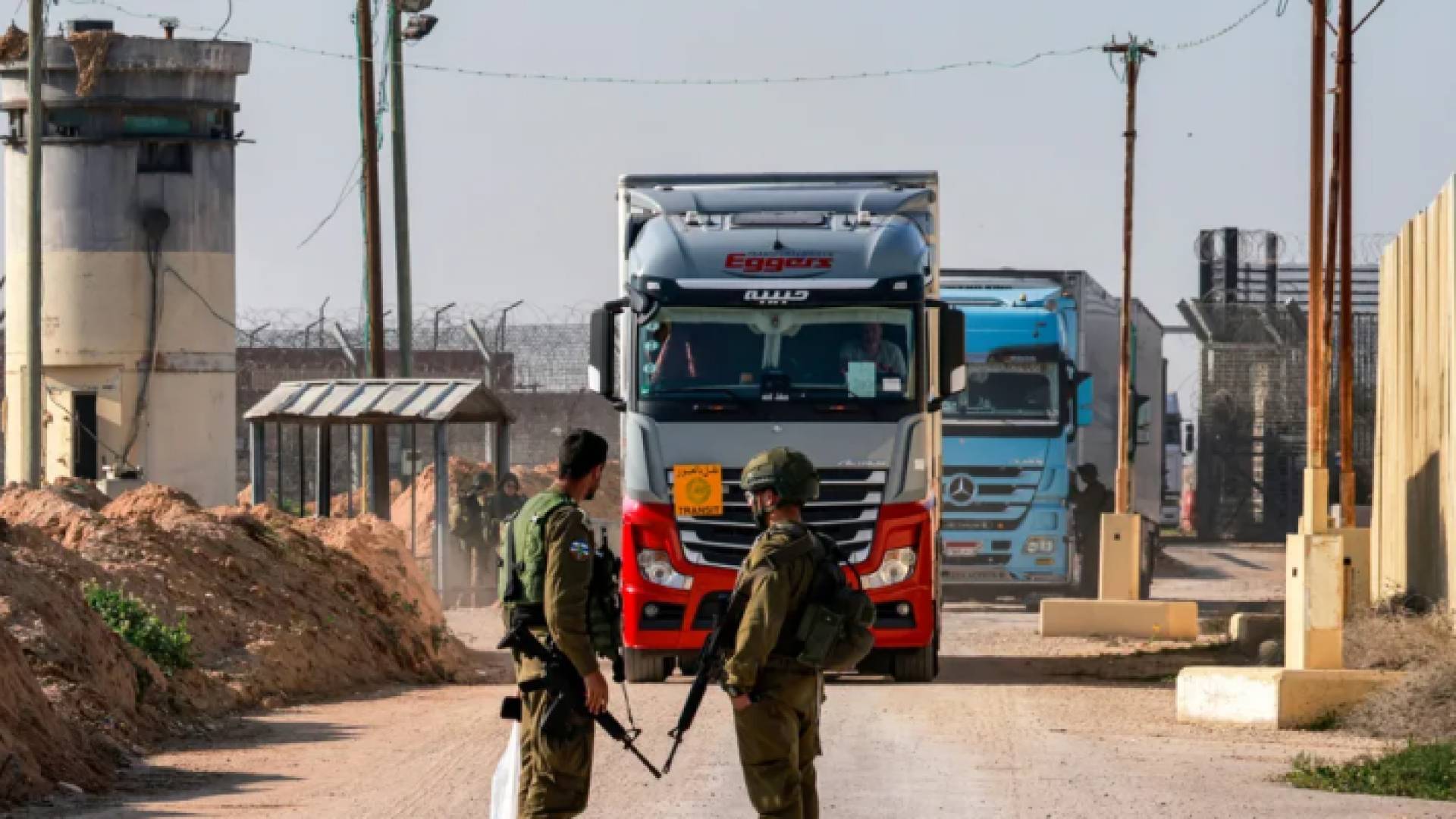 جنود من الاحتلال يقفون أمام شاحنات عند معبر كرم أبو سالم