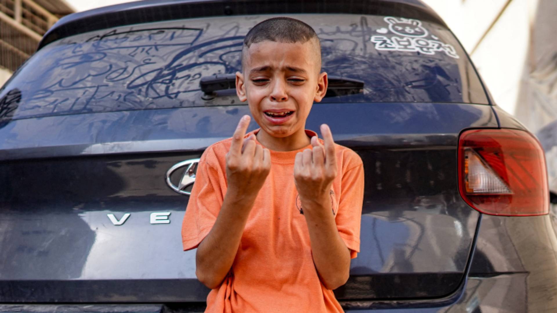 طفل فلسطيني يبكي عقب استشهاد شقيقته بقصف للاحتلال على المغازي وسط قطاع غزة - AFP