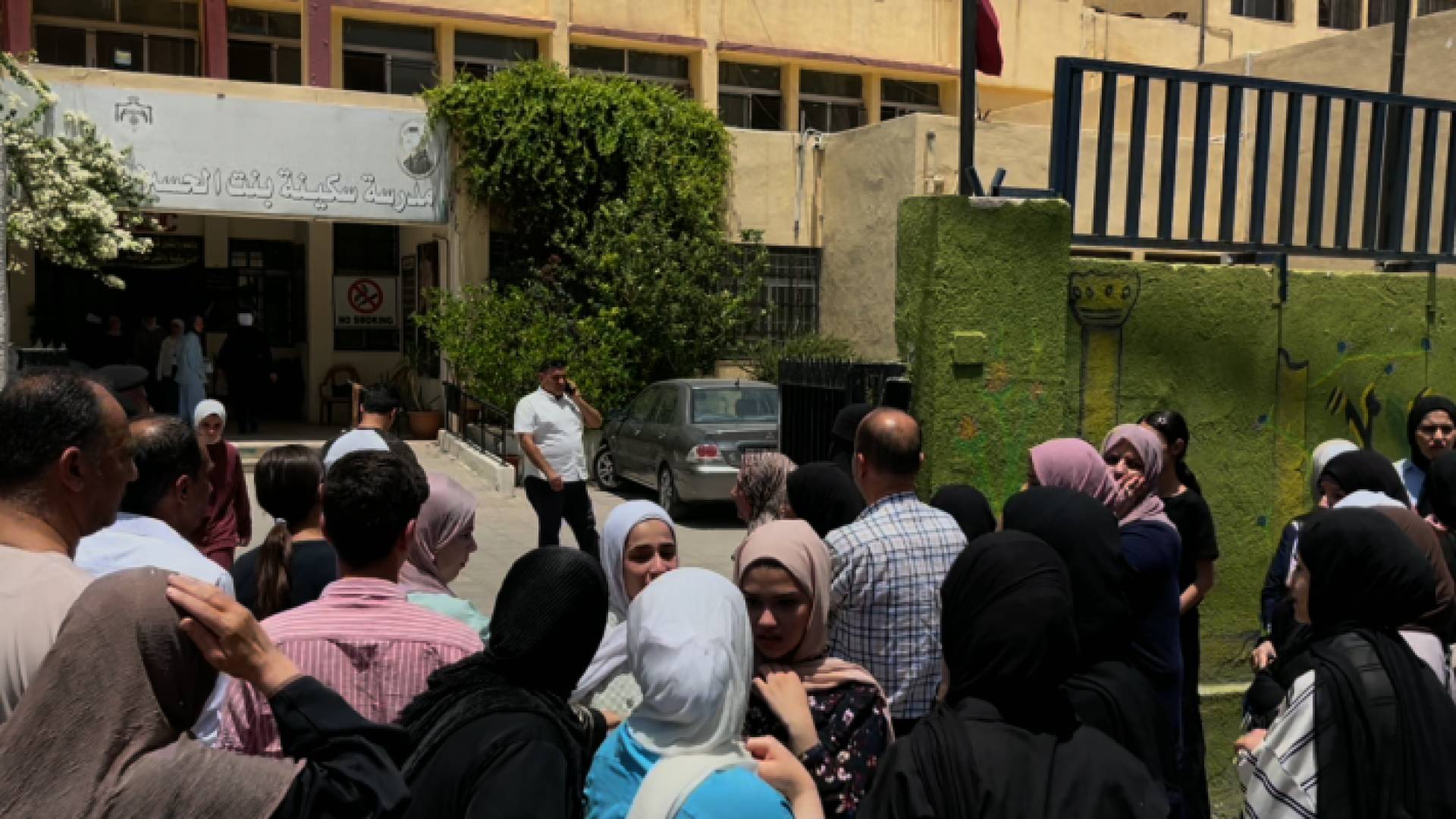 ذوو طلبة ينتظرون أبناءهم أمام إحدى مدارس الاختبارات