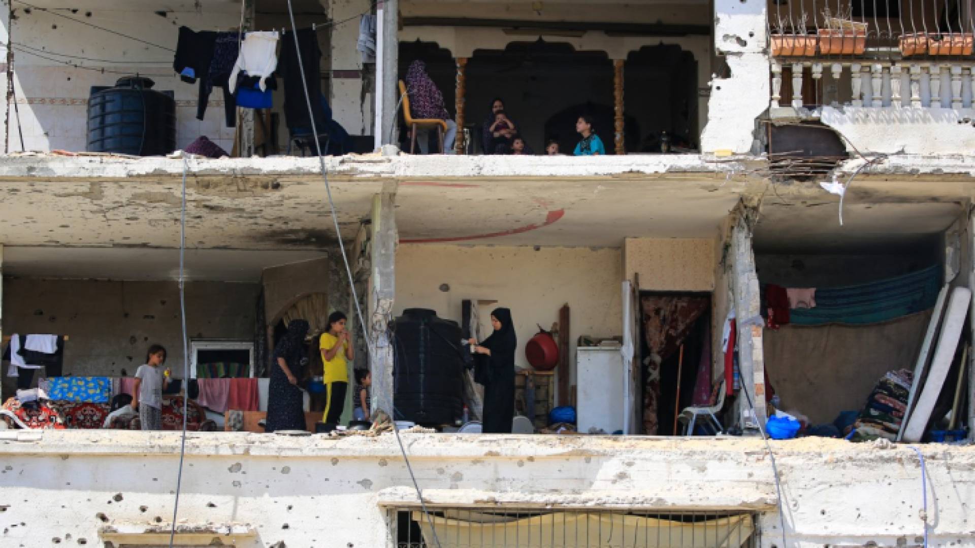 عائلات فلسطينية تعود إلى منازلها المدمرة في مبنى سكني تعرض لقصف الاحتلال في مدينة خان يونس