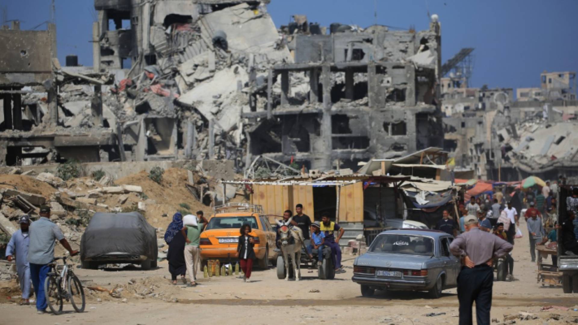 فلسطيني يسير في شارع بجوار المباني المدمرة بينما يعود بعض السكان إلى مدينة خان يونس