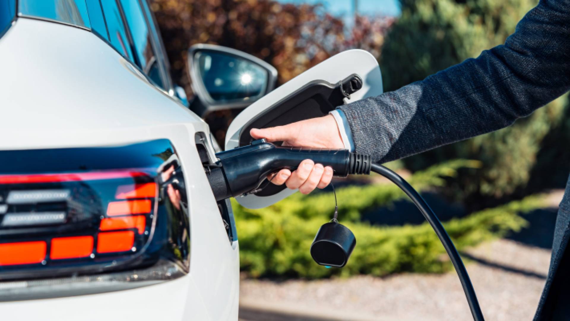 شخص يقوم بشحن مركبة كهربائية
