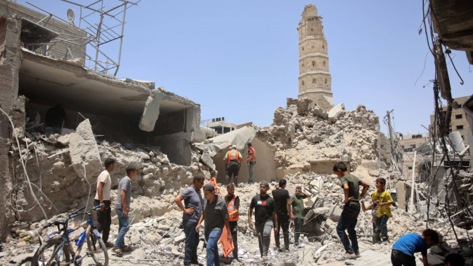 رجال الإنقاذ يقفون على أنقاض المباني المدمرة في أعقاب قصف الاحتلال بمدينة غزة