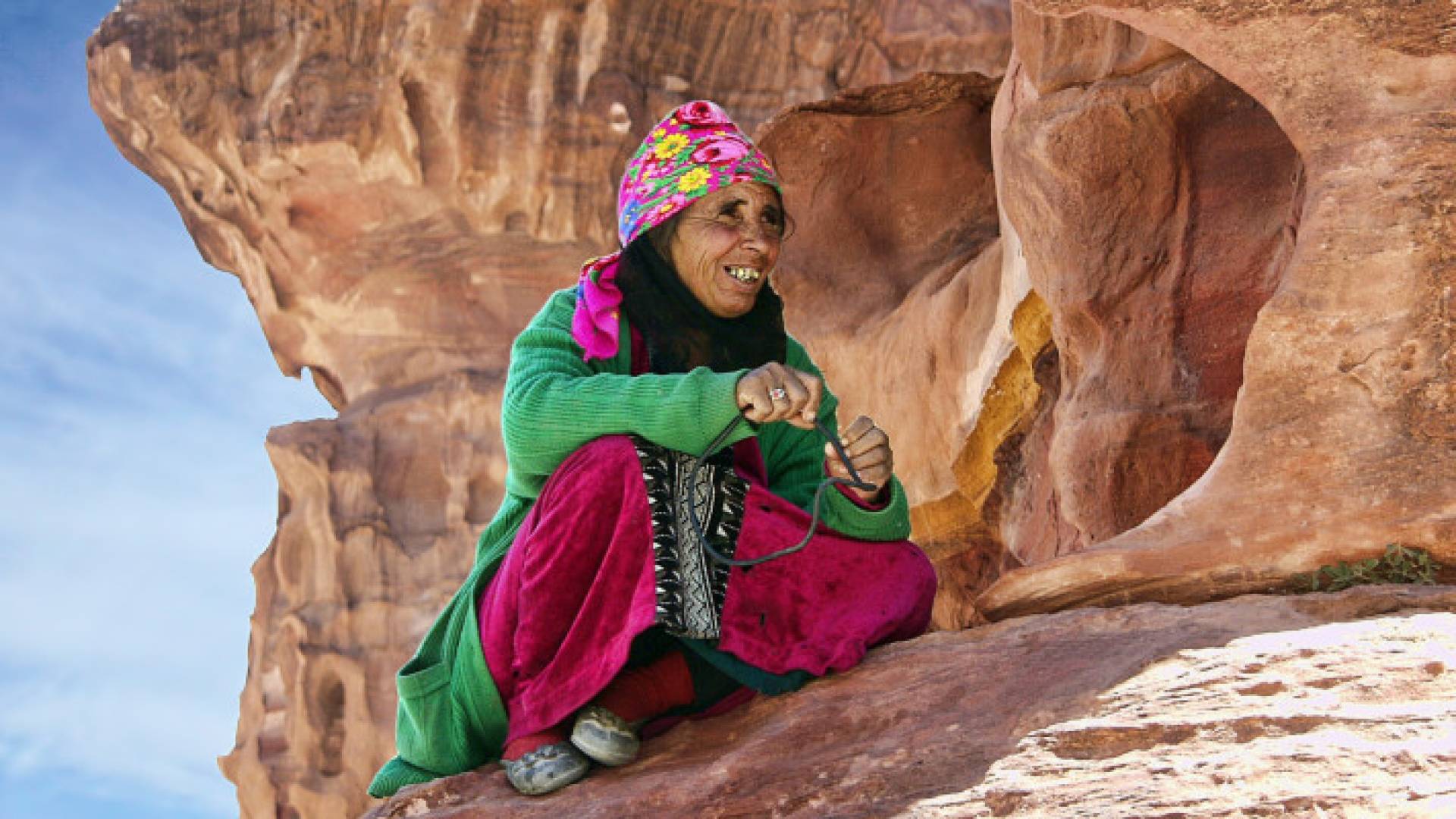 أردنية ترتدي الزي التراثي الأردني وتجلس في منطقة أثرية