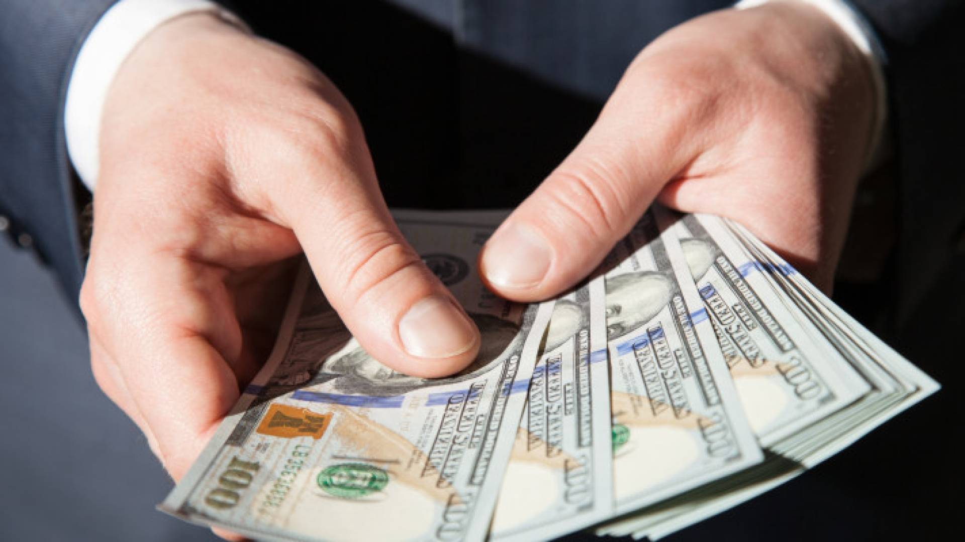 شخص يحمل دولارات