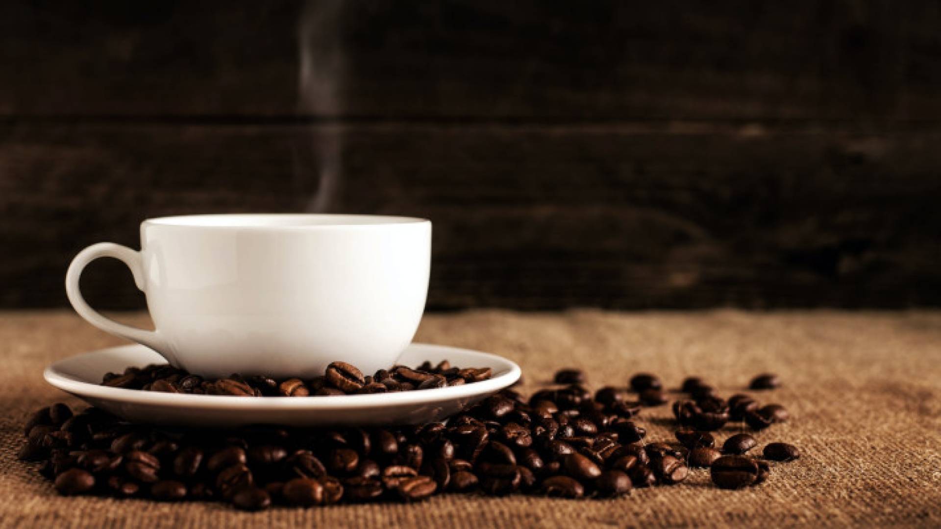 فنجان قهوة بجانب حبوب البن