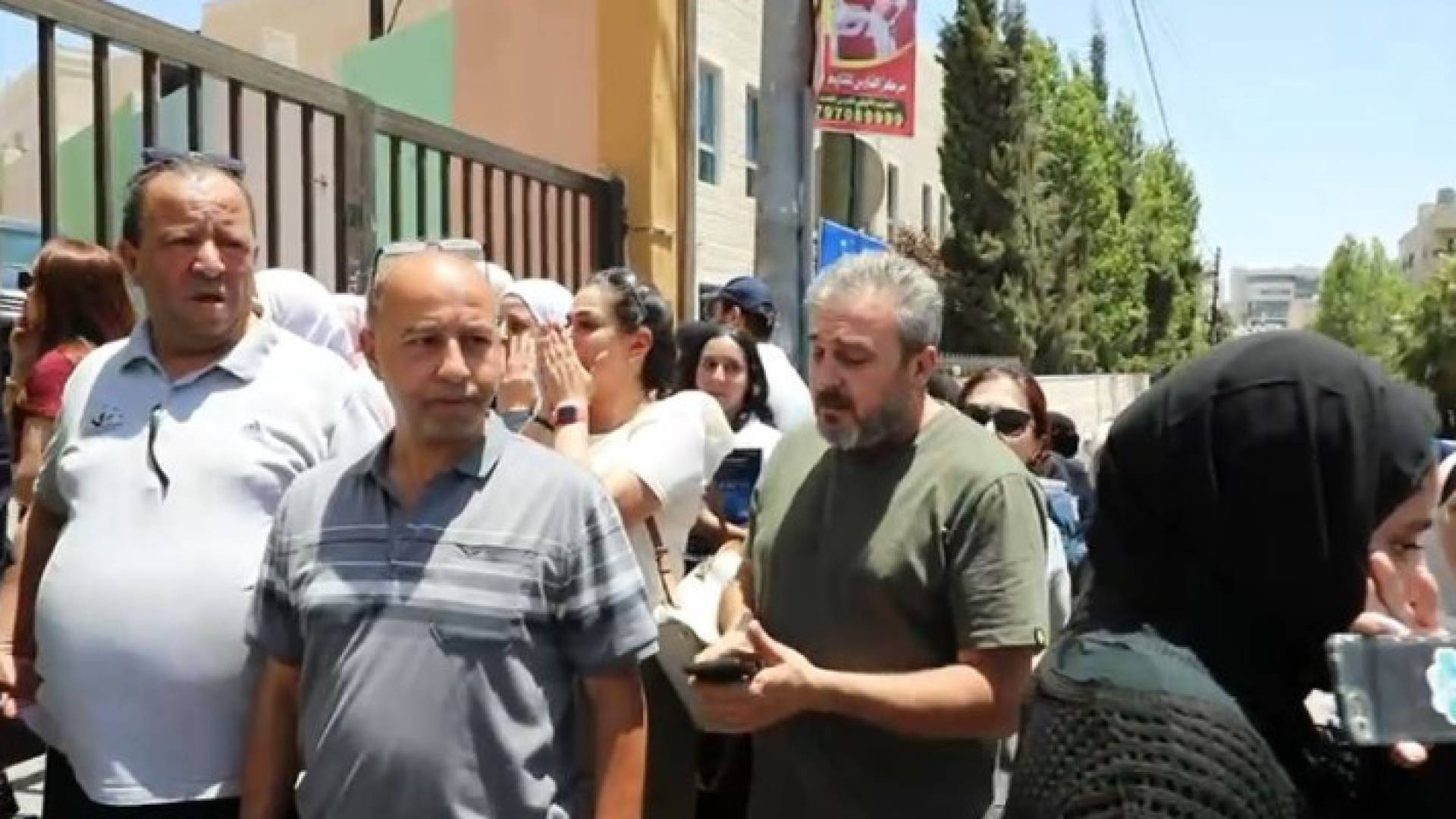 أولياء أمور طالبات توجيهي أمام إحدى القاعات في العاصمة عمان