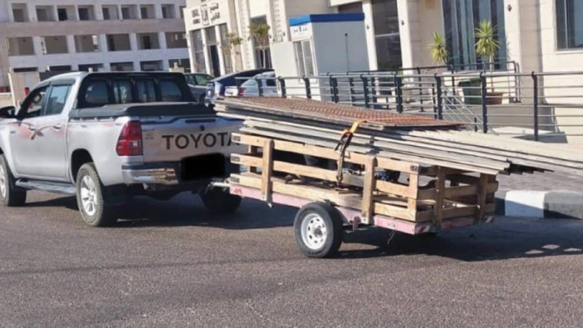 بيك أب يجر عربة تحمل ألواح الزينكو