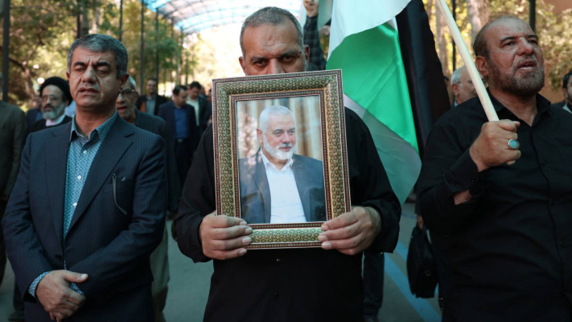 إيرانبون يرفعون العلم الفلسطيني وصورة إسماعيل هنية حماس خلال تجمع حاشد في جامعة طهران