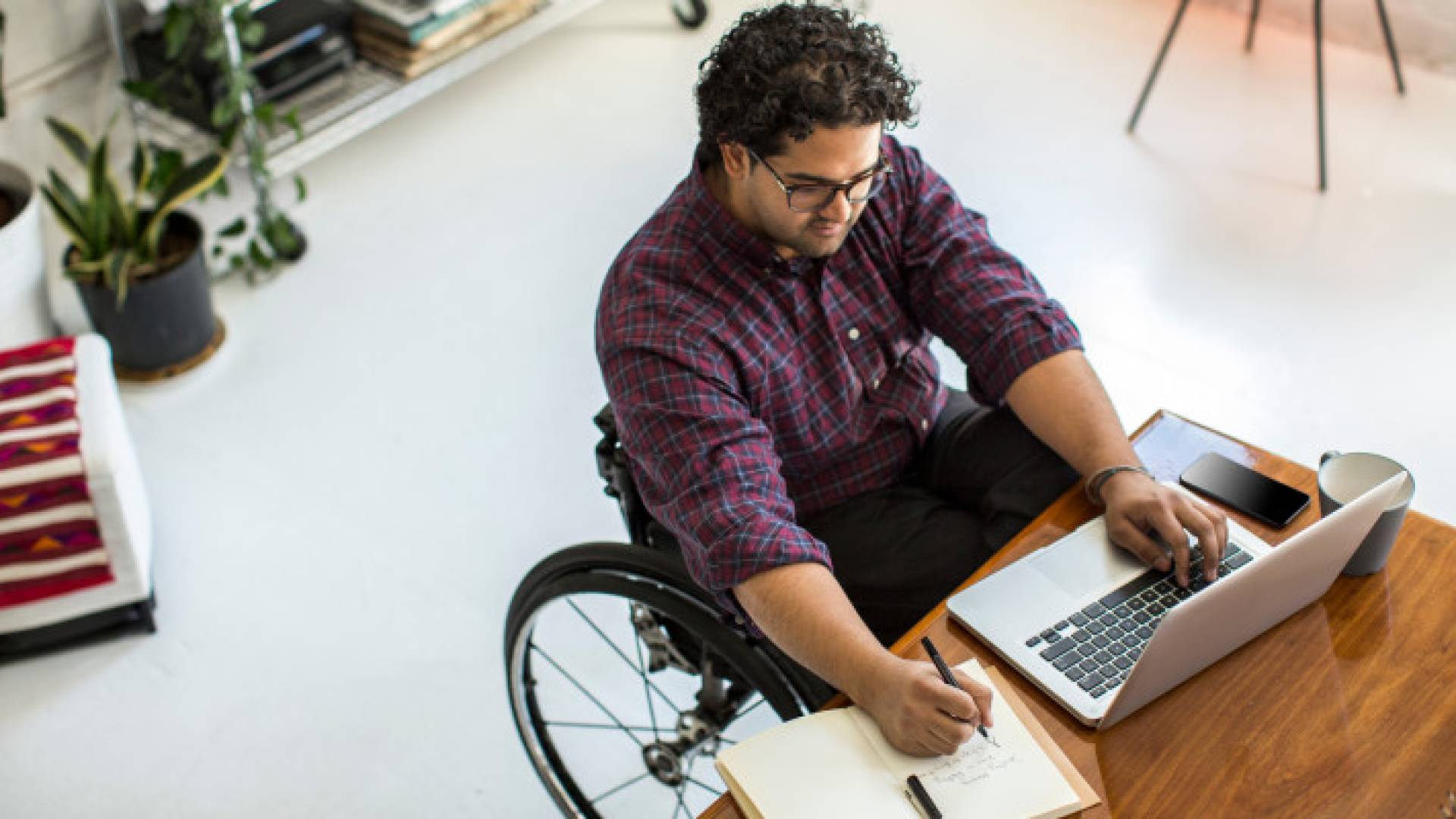 شخص من ذوي الإعاقة الحركية يقوم بتأدية عمله - تعبيرية