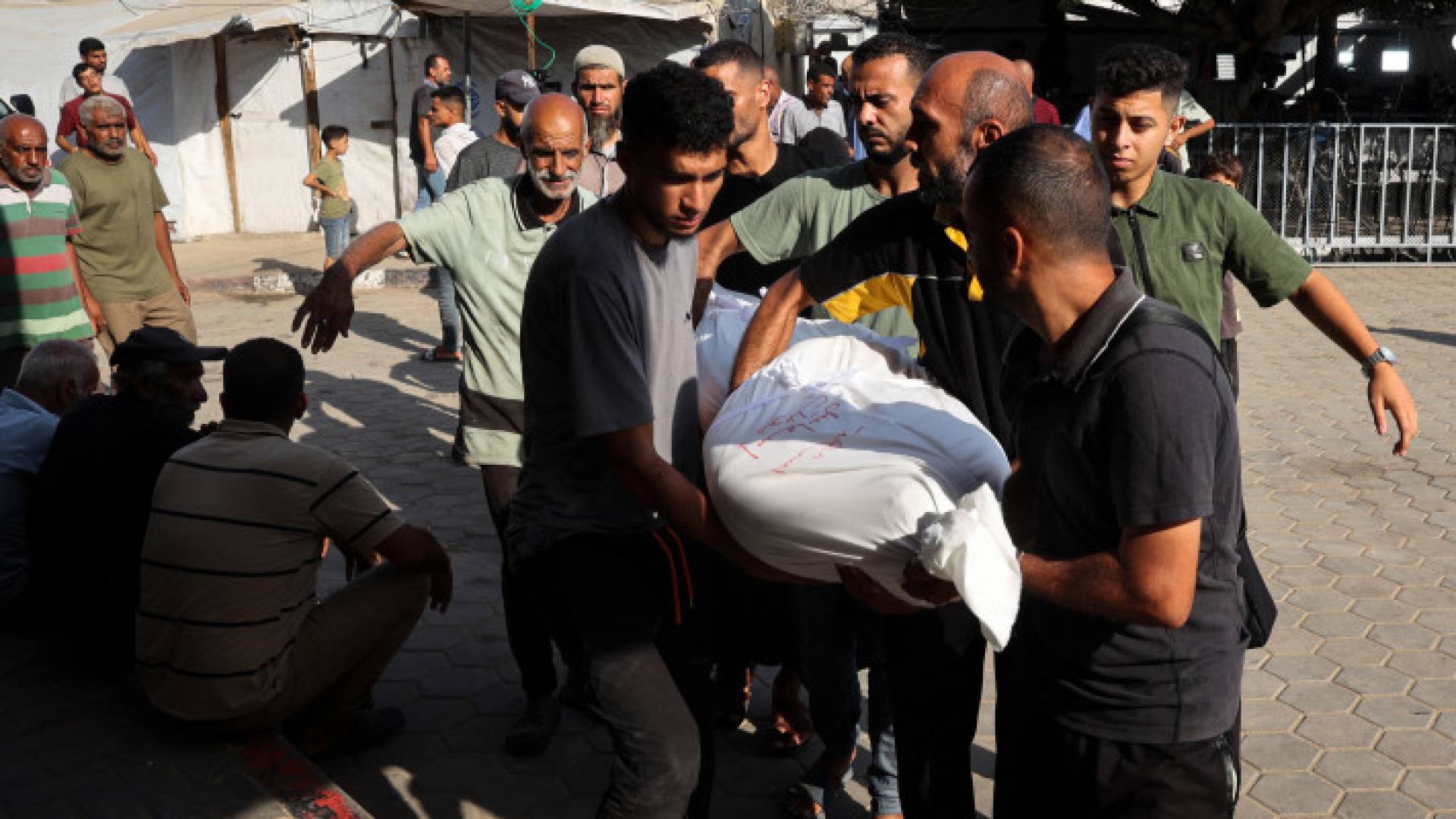 فلسطينيون يحملون شهيدا في باحة مستشفى شهداء الأقصى