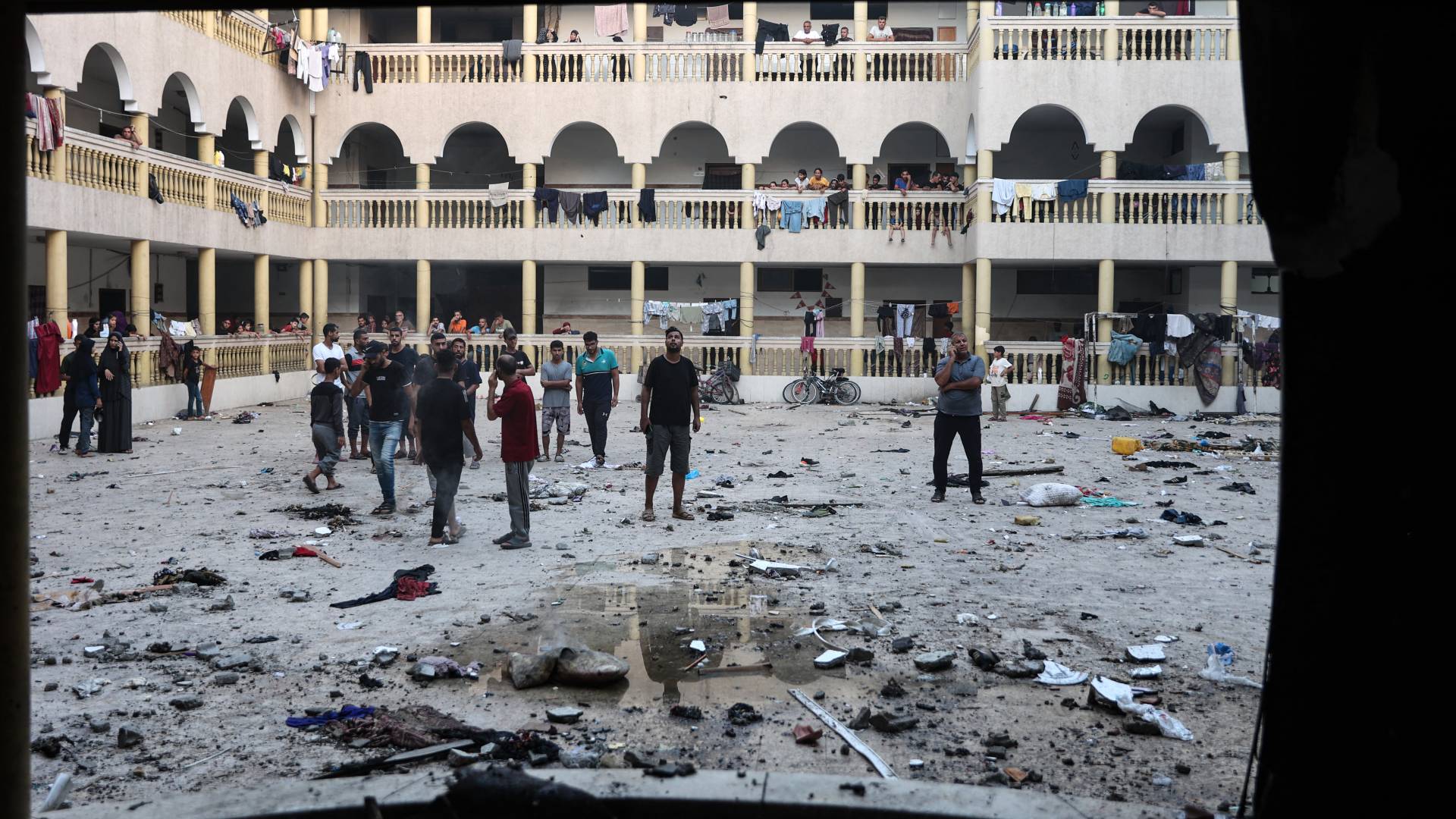 نازحون فلسطينيون يتجمعون في ساحة مدرسة تعرضت لهجوم إسرائيلي في مدينة غزة