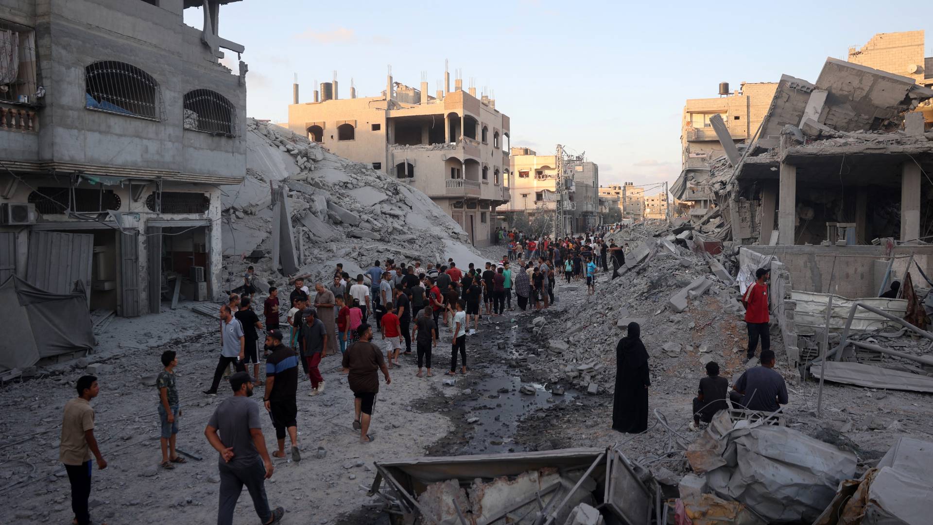 فلسطينيون يتجمعون لتفقد مبنى بعد قصفه من الاحتلال في مخيم النصيرات في وسط قطاع غزة