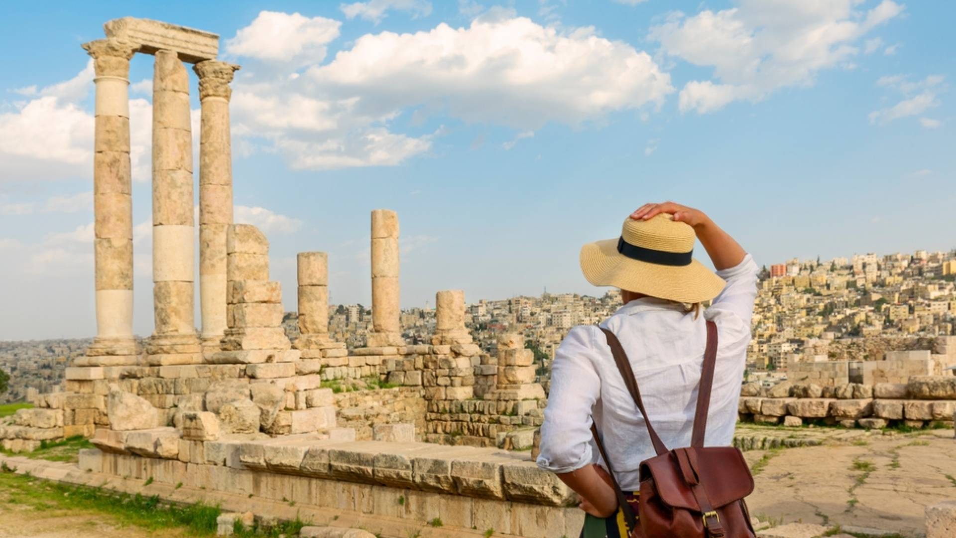 فتاة تنظر إلى معبد هرقل في قلعة بالعاصمة عمان