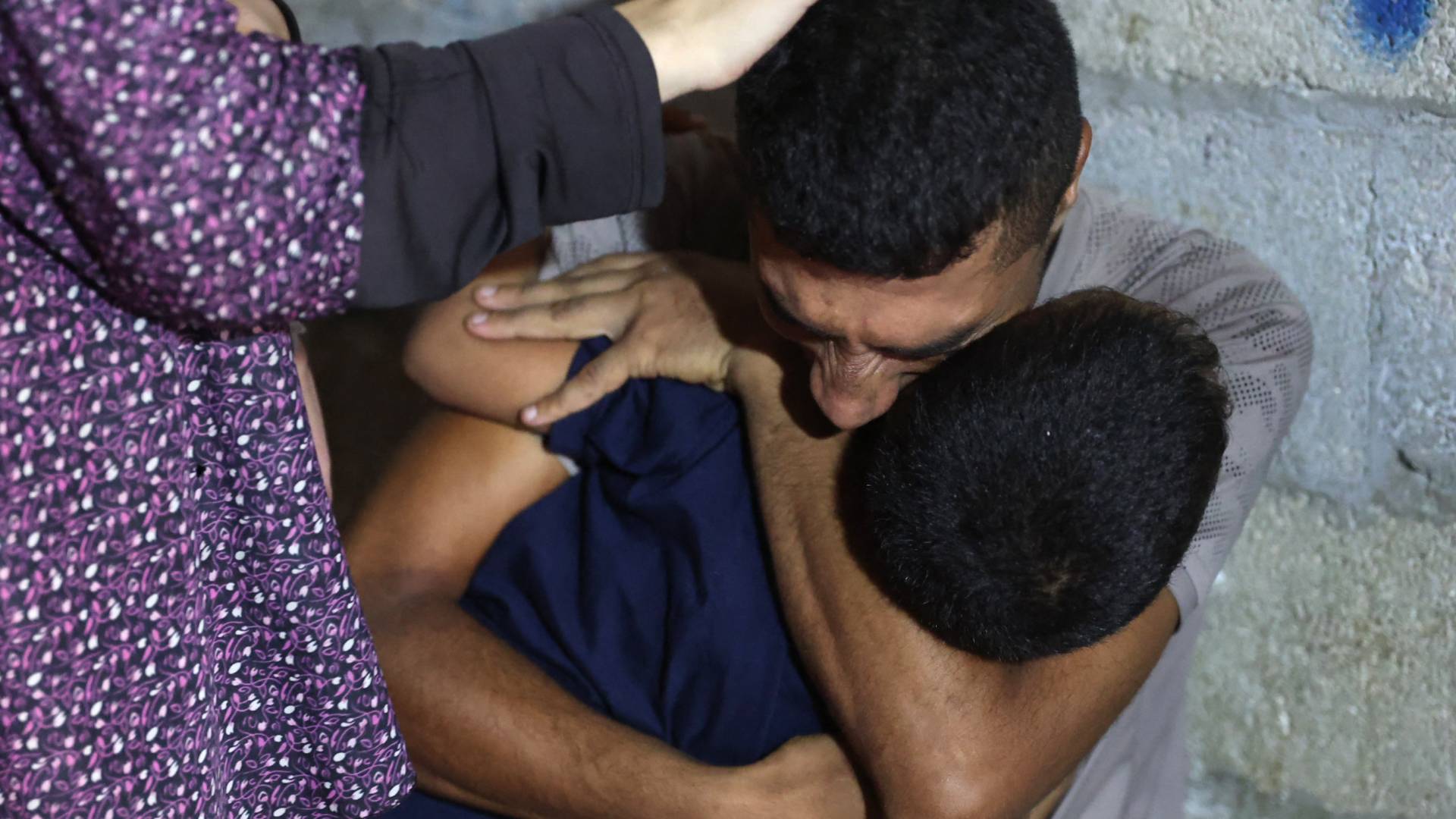 فلسطيني يحتضن شقيقه الشهيد في قطاع غزة "أ ف ب"