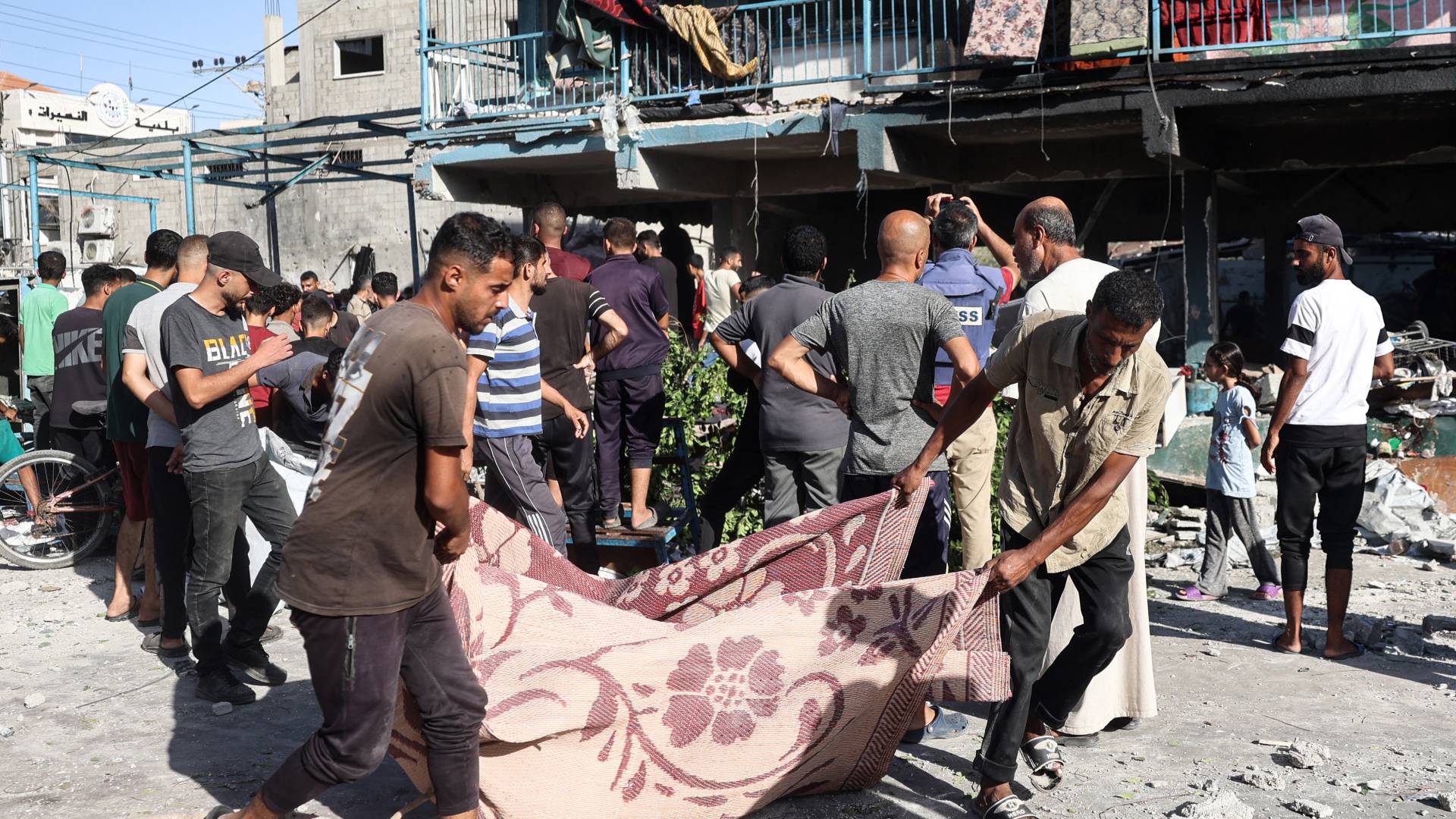 فلسطينيون يحملون جثمان أحد الشهداء في مدرسة الجوني (الجاعوني) في النصيرات