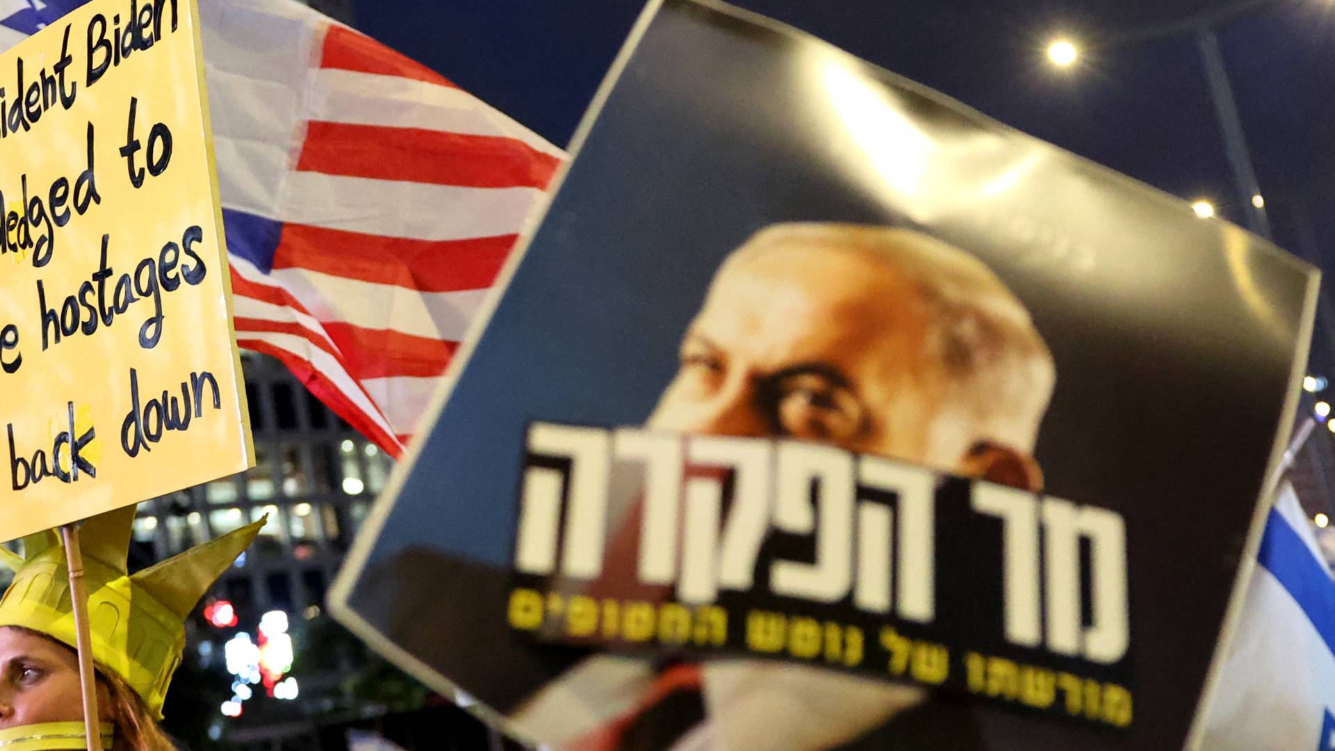 متظاهرون يرفعون اللافتات خلال احتجاج ضد حكومة نتنياهو