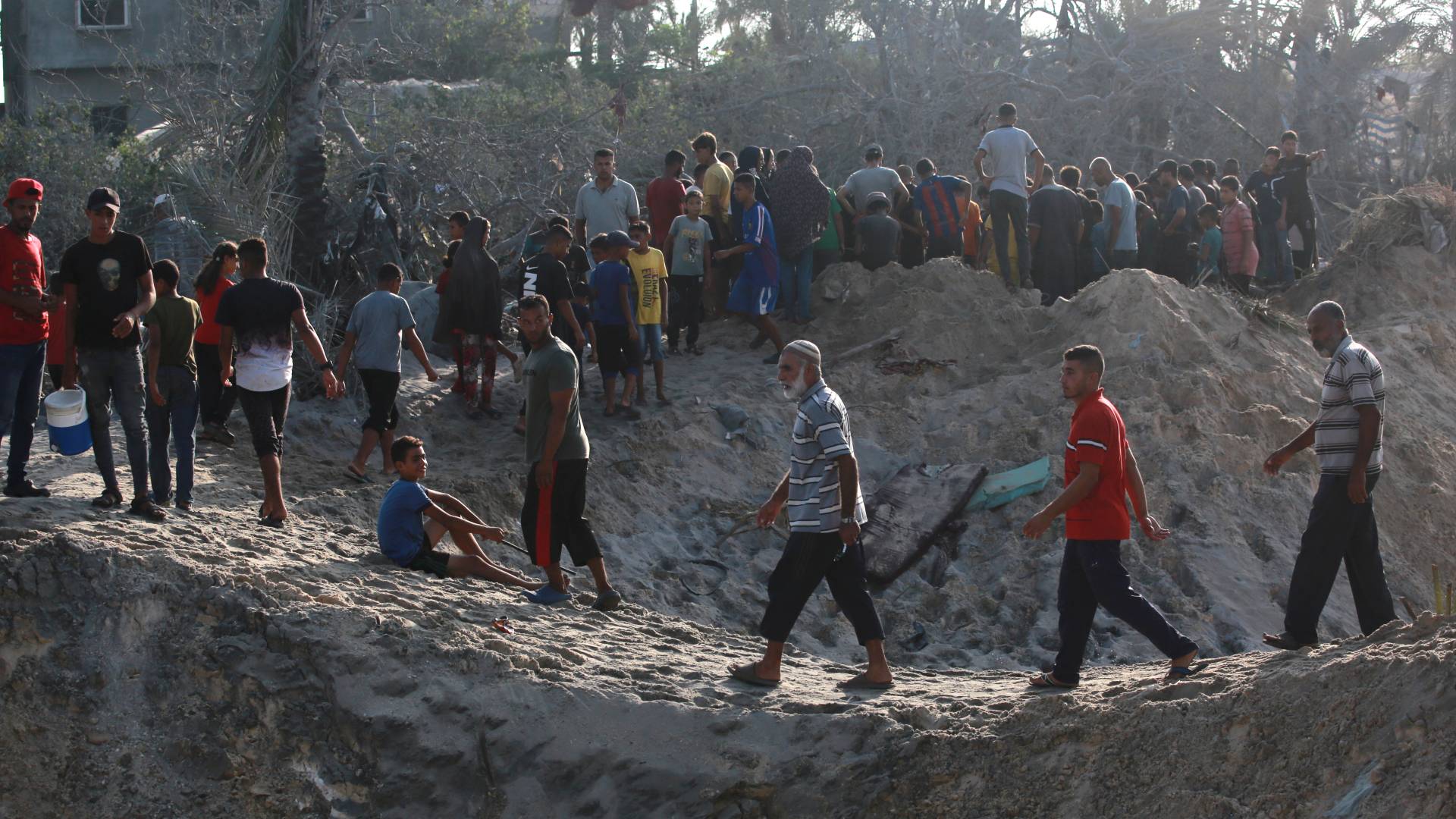 فلسطينيون في موقع ضربات الاحتلال في مواصي خان يونس