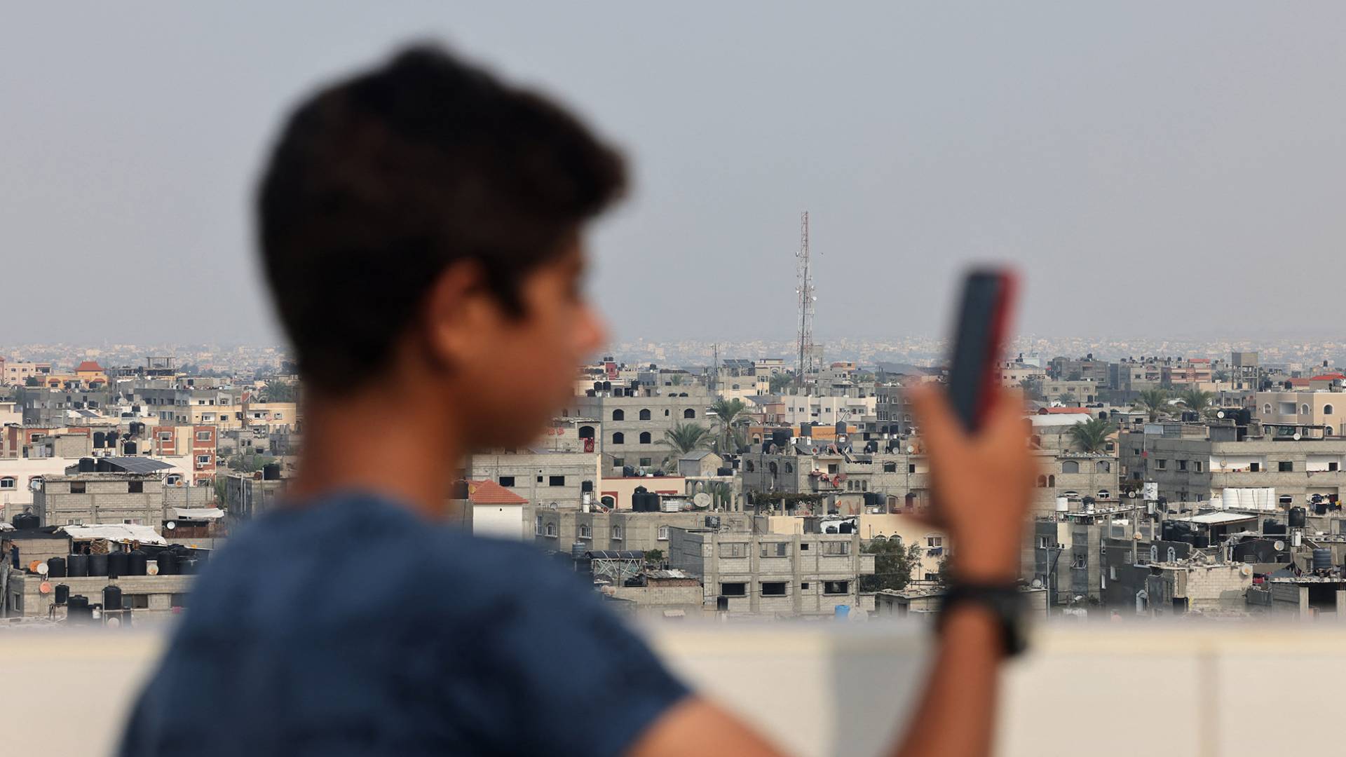 فتى فلسطيني يحمل هاتف في قطاع غزة