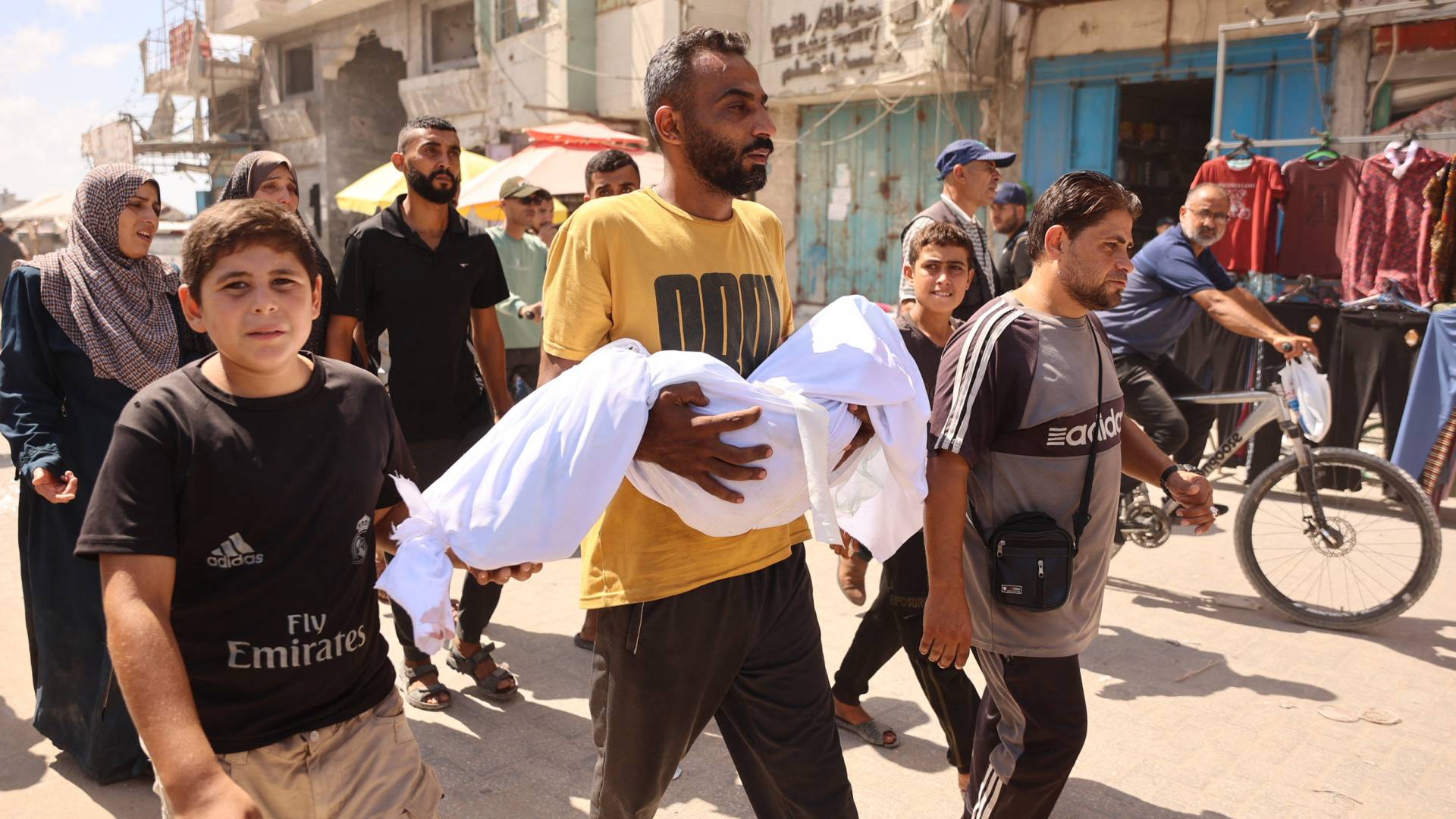 فلسطيني يحمل جثمان طفله الشهيد