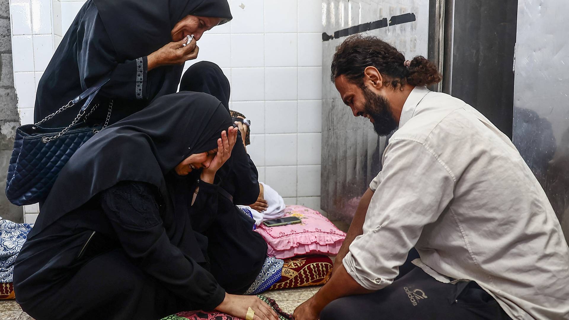 فلسطينيون يبكون بالقرب من جثامين شهدائهم في قطاع غزة